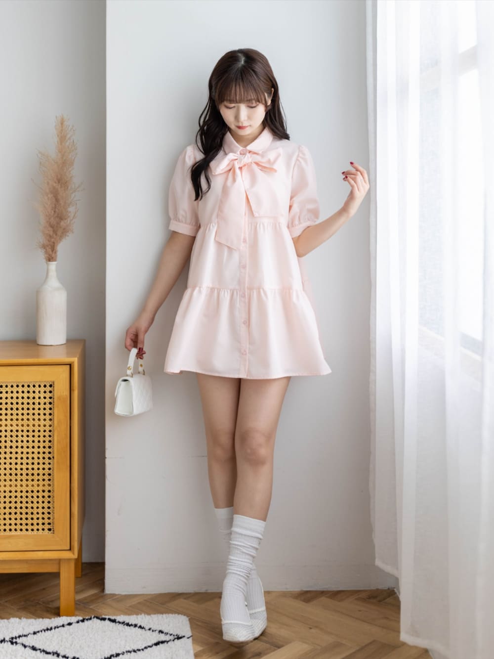 ホワイト系のパンプス、ピンク系のワンピースを着用したレディースの春コーディネートの2枚目の写真