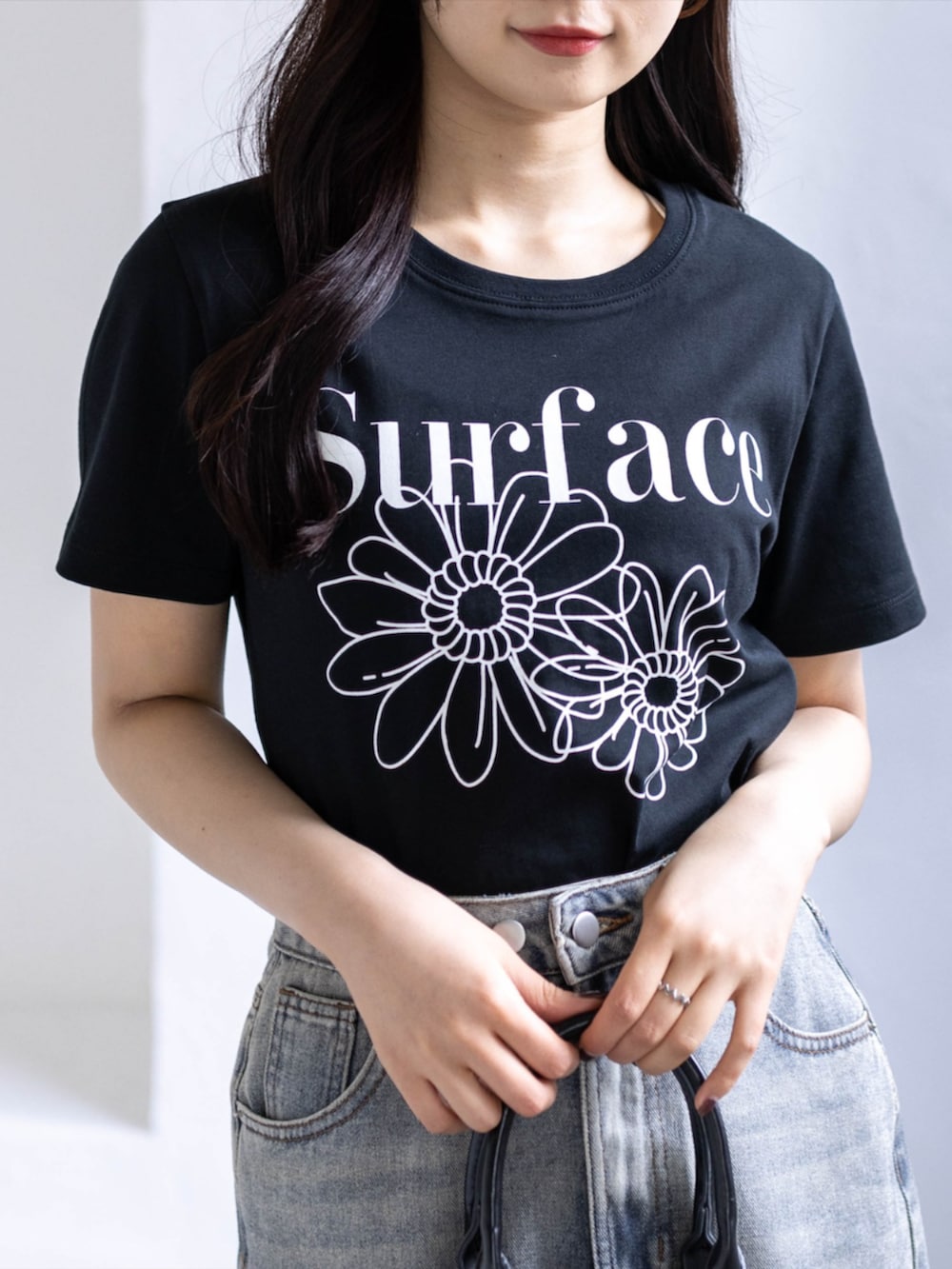 ホワイト系のスニーカー、ブルー系のスカート、ブラック系のTシャツ/カットソーを着用したレディースの春コーディネートの6枚目の写真