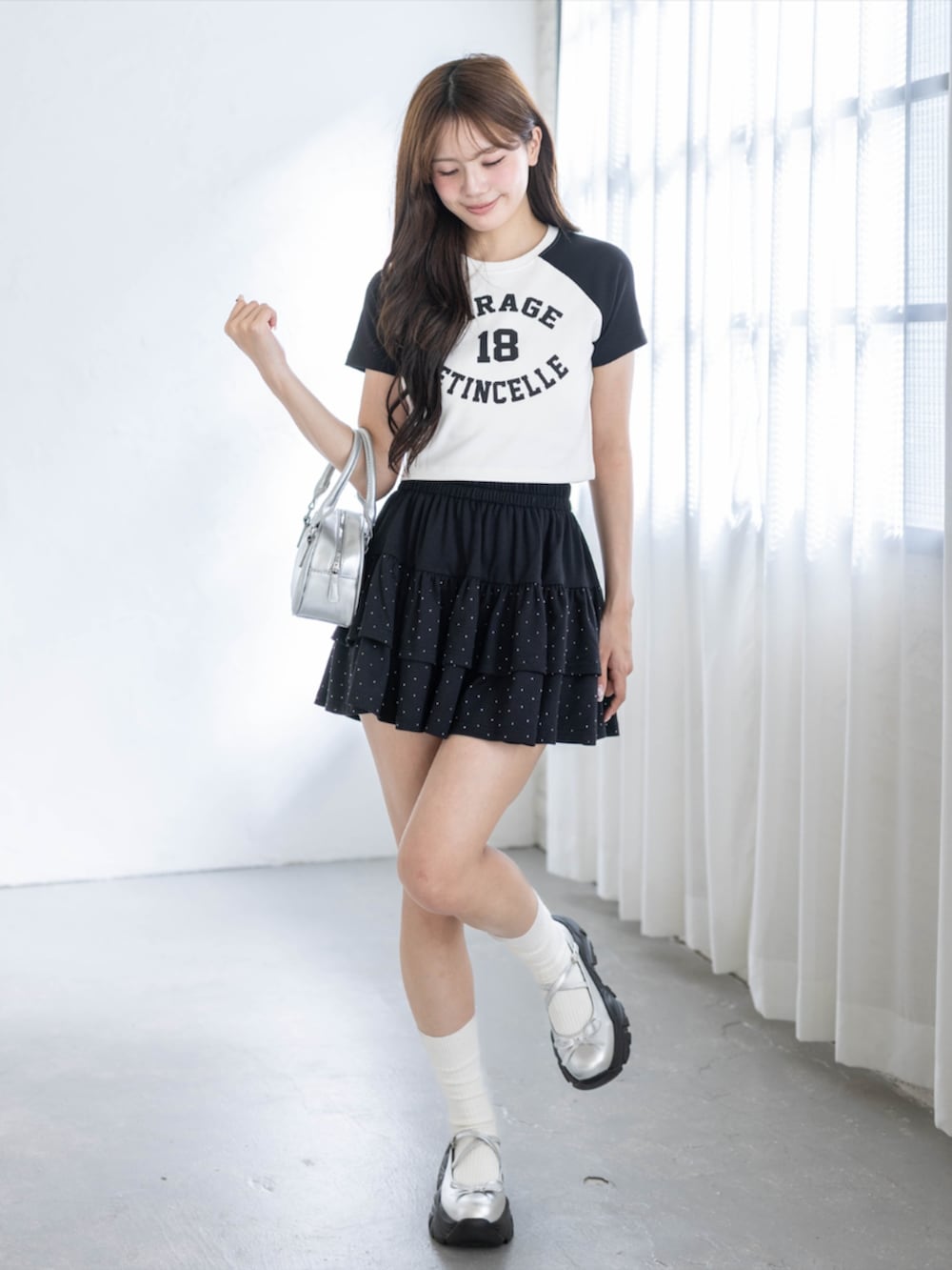 ブラック系のスカート、シルバー系のスニーカー、ブラック系のTシャツ/カットソーを着用したレディースの春コーディネートの2枚目の写真