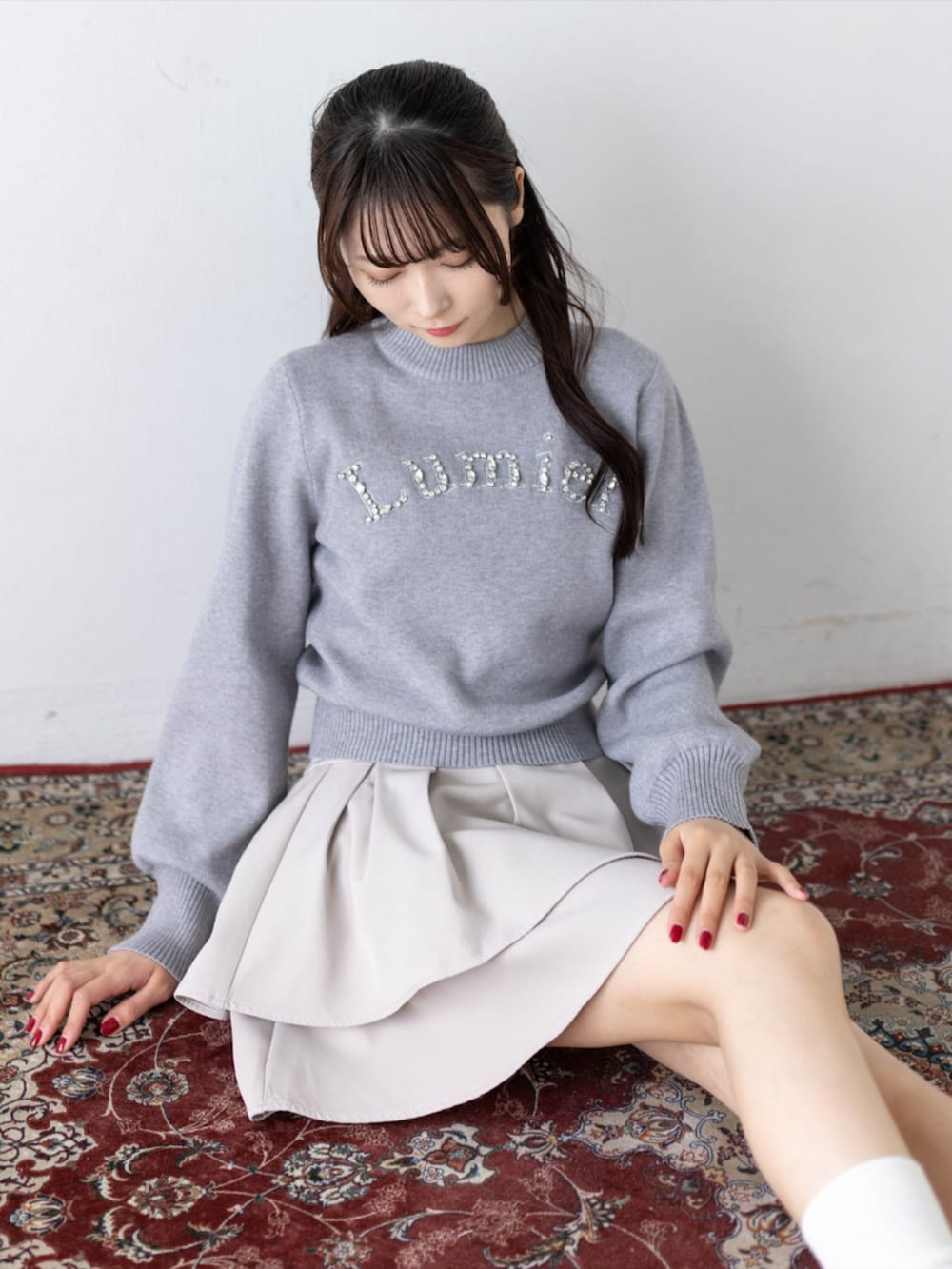 ブラック系のローファー、グレー系のニット/セーター、ベージュ系のスカートを着用したレディースの秋コーディネートの9枚目の写真