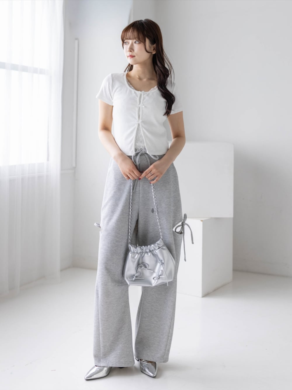 シルバー系のパンプス、ホワイト系のTシャツ/カットソー、グレー系のスウェットパンツを着用したレディースの春コーディネートの2枚目の写真