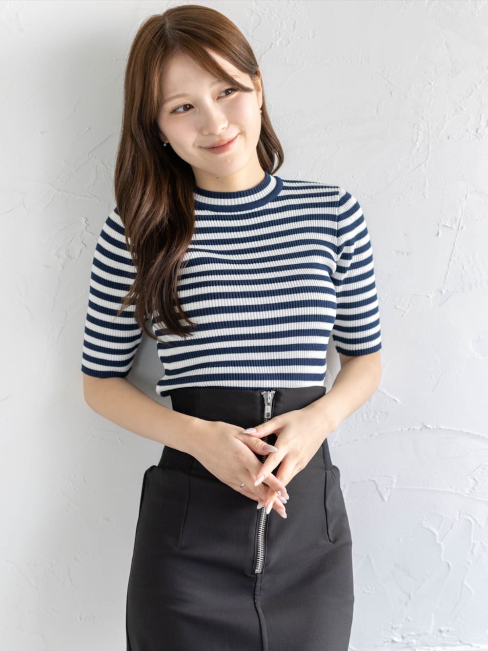 ブラック系のスカート、ブルー系のニット/セーター、ブラック系のパンプスを着用したレディースの夏コーディネートの3枚目の写真
