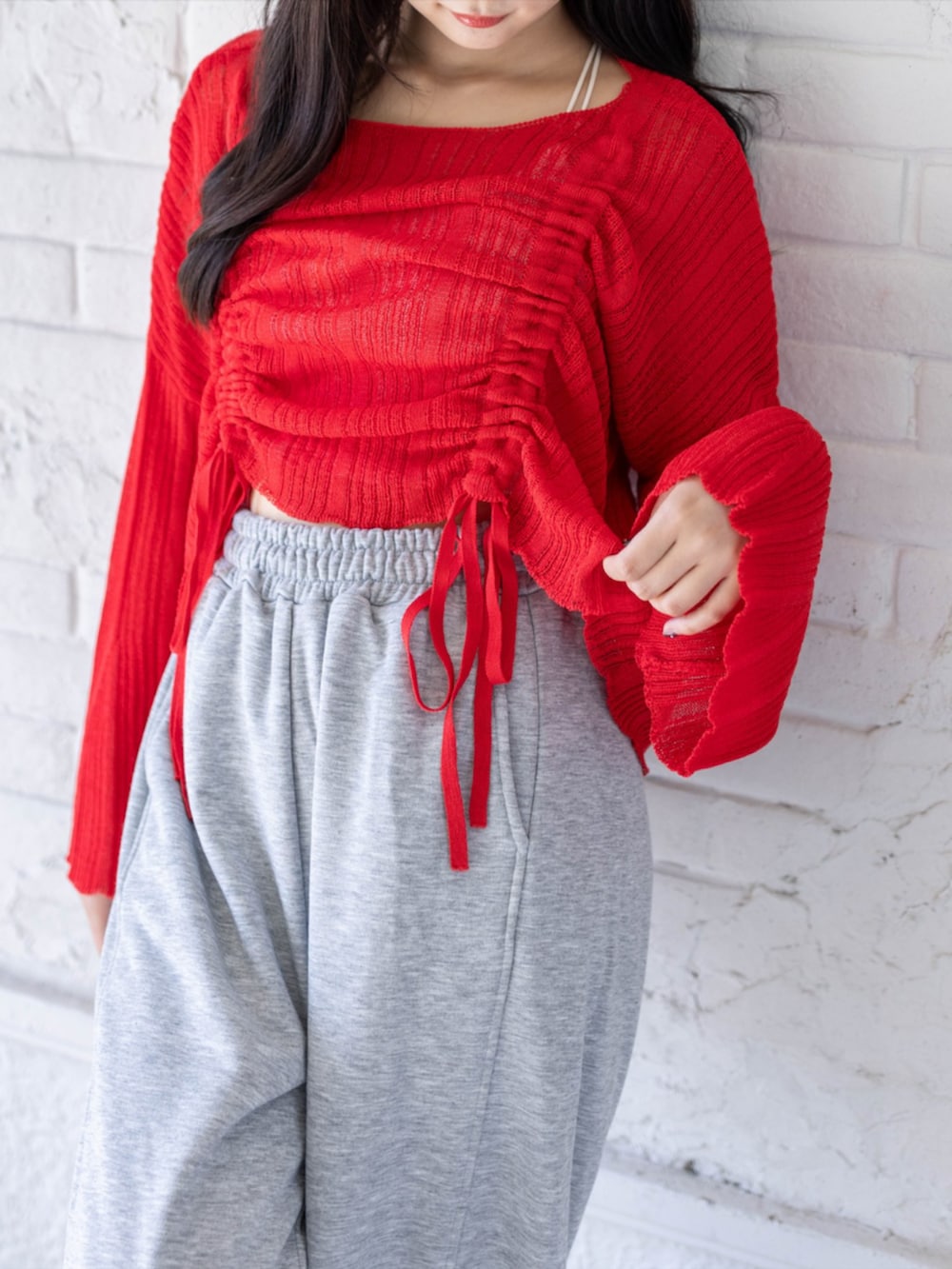 ホワイト系のスニーカー、グレー系のスウェットパンツ、レッド系のニット/セーターを着用したレディースの春コーディネートの4枚目の写真