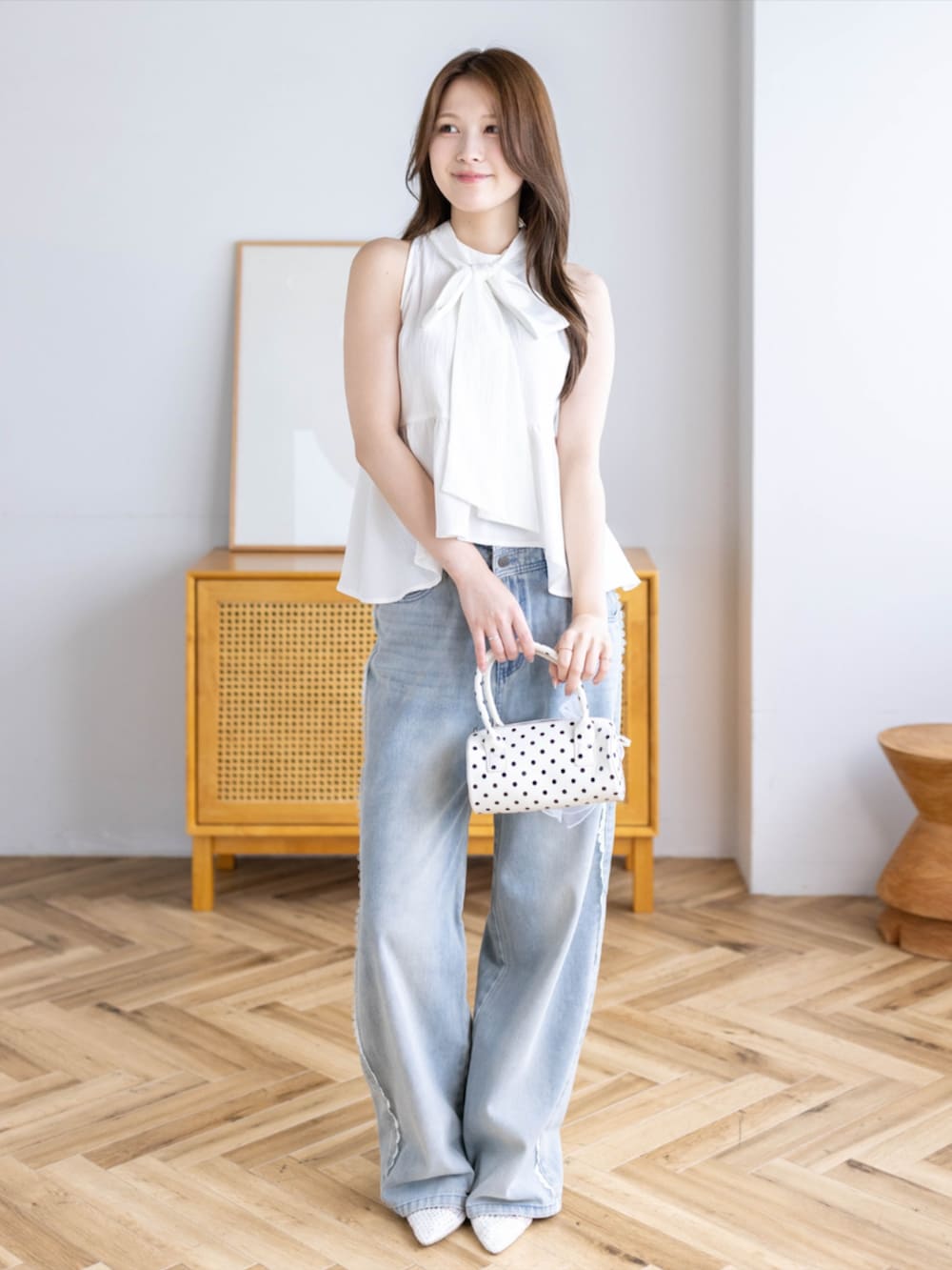 ブルー系のデニムパンツ、ホワイト系のパンプス、ホワイト系のシャツ/ブラウスを着用したレディースの夏コーディネートの3枚目の写真