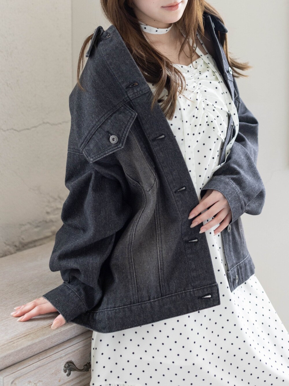 ブラック系のブーツ、ブラック系のデニムジャケット、ホワイト系のワンピースを着用したレディースの春コーディネートの6枚目の写真