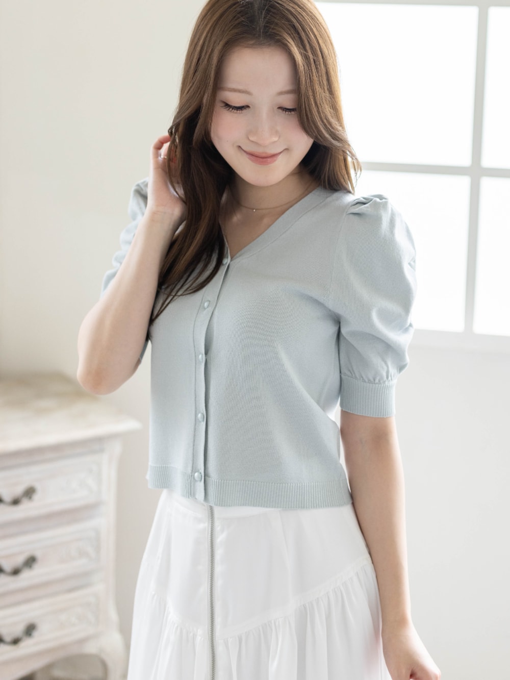 ホワイト系のスカート、ホワイト系のパンプス、グレー系のカーディガン/ボレロを着用したレディースの春コーディネートの5枚目の写真