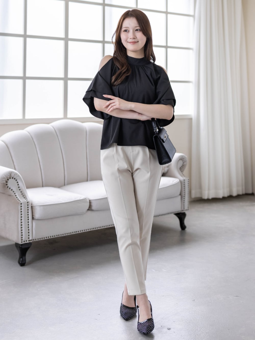 ホワイト系のその他パンツ、ブラック系のハンドバッグ、ブラック系のパンプスを着用したレディースの春コーディネートの2枚目の写真