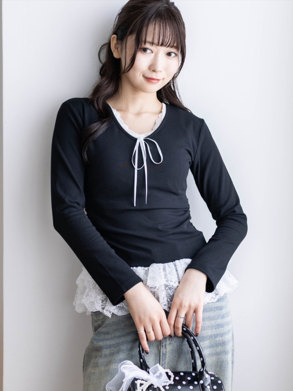 ブラック系のパンプス、ブラック系のボストンバッグ、ブルー系のデニムパンツを着用したレディースの夏コーディネートの5枚目の写真