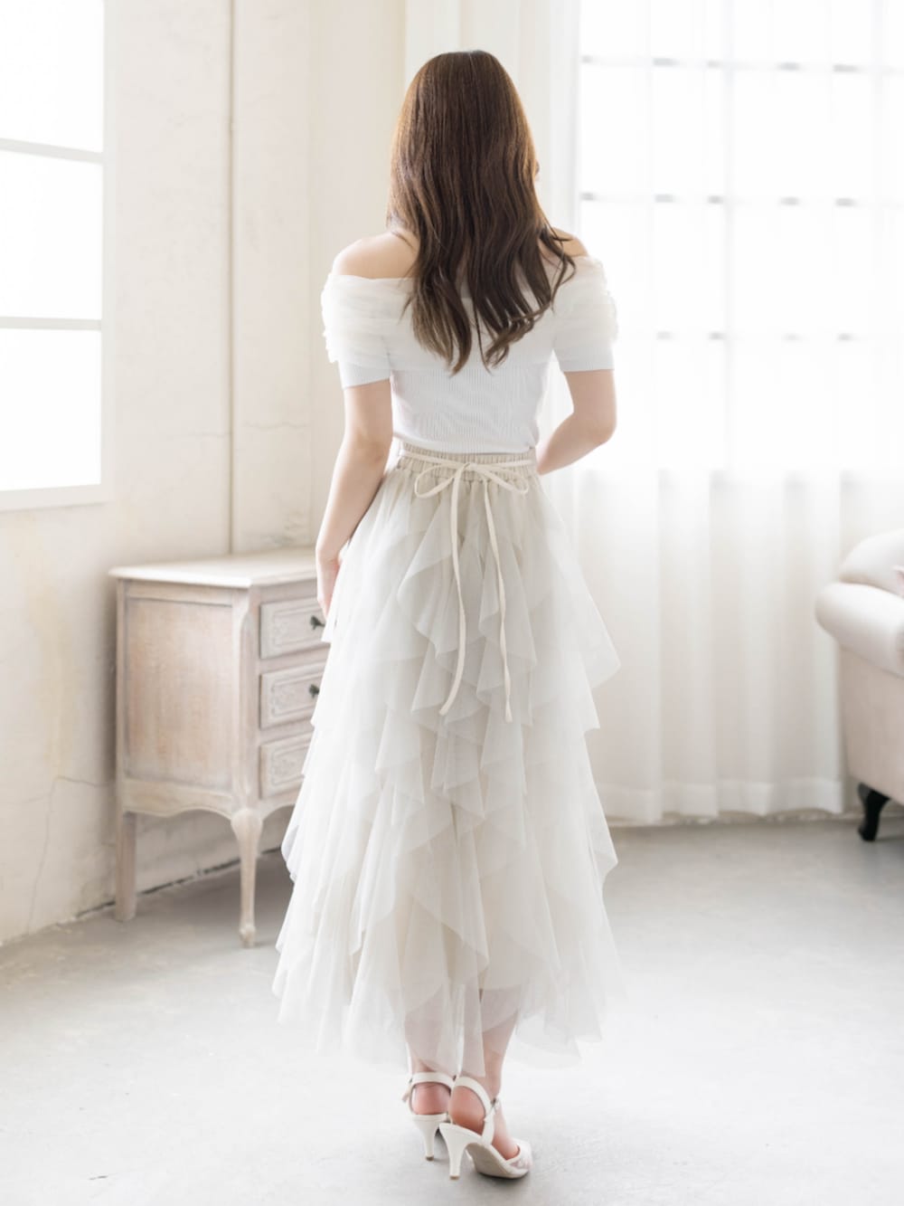 ホワイト系のニット/セーター、ホワイト系のパンプス、ホワイト系のスカートを着用したレディースの春コーディネートの3枚目の写真