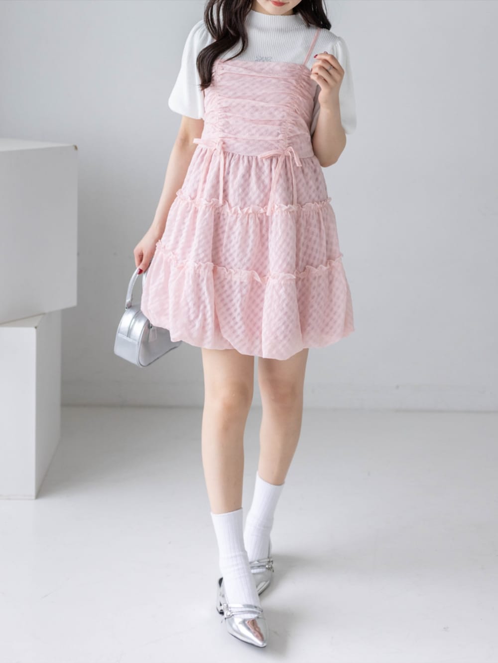 シルバー系のパンプス、ホワイト系のニット/セーター、ピンク系のワンピースを着用したレディースの春コーディネートの6枚目の写真