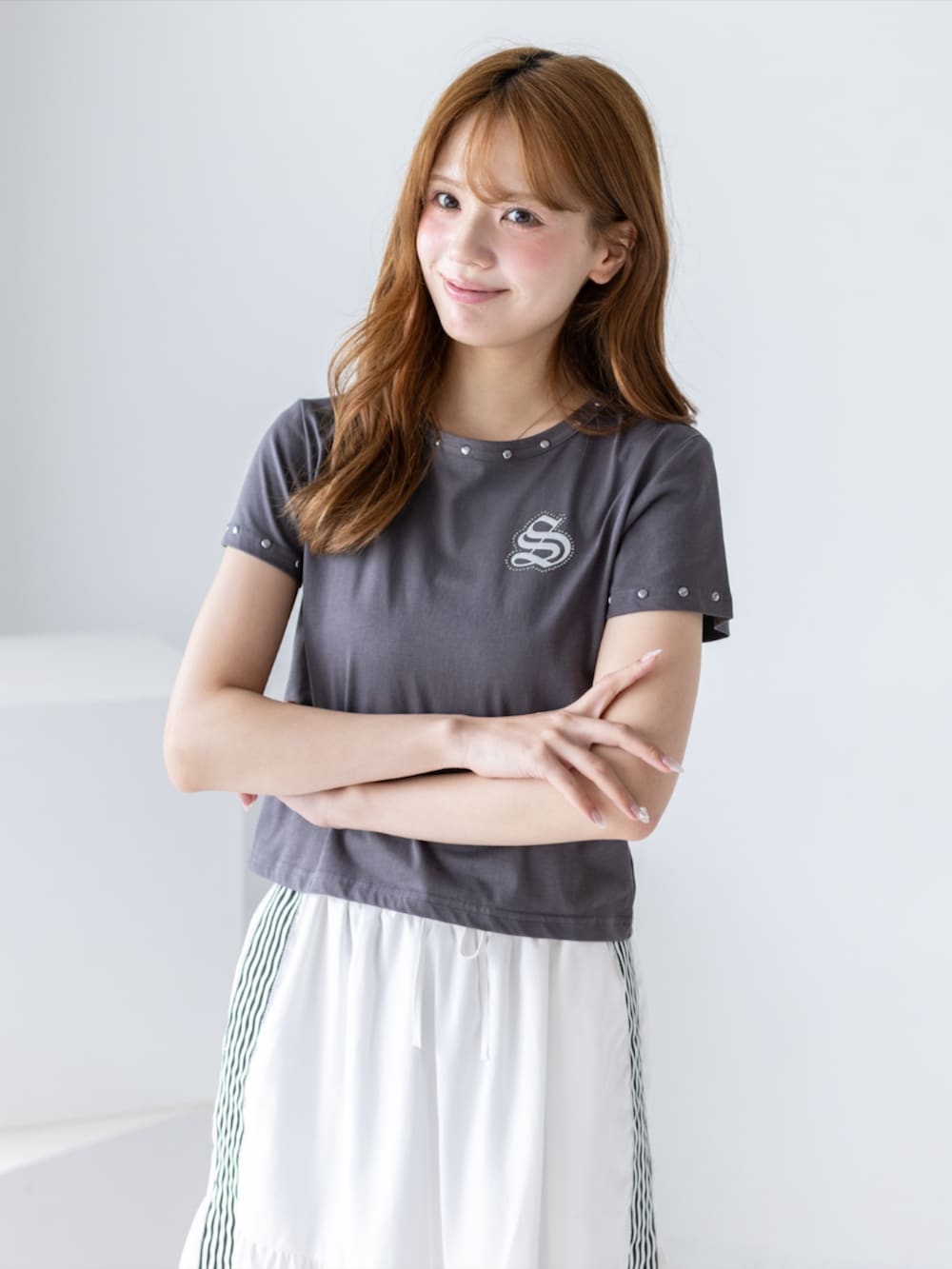 ブラック系のブーツ、ホワイト系のスカート、グレー系のTシャツ/カットソーを着用したレディースの夏コーディネートの7枚目の写真