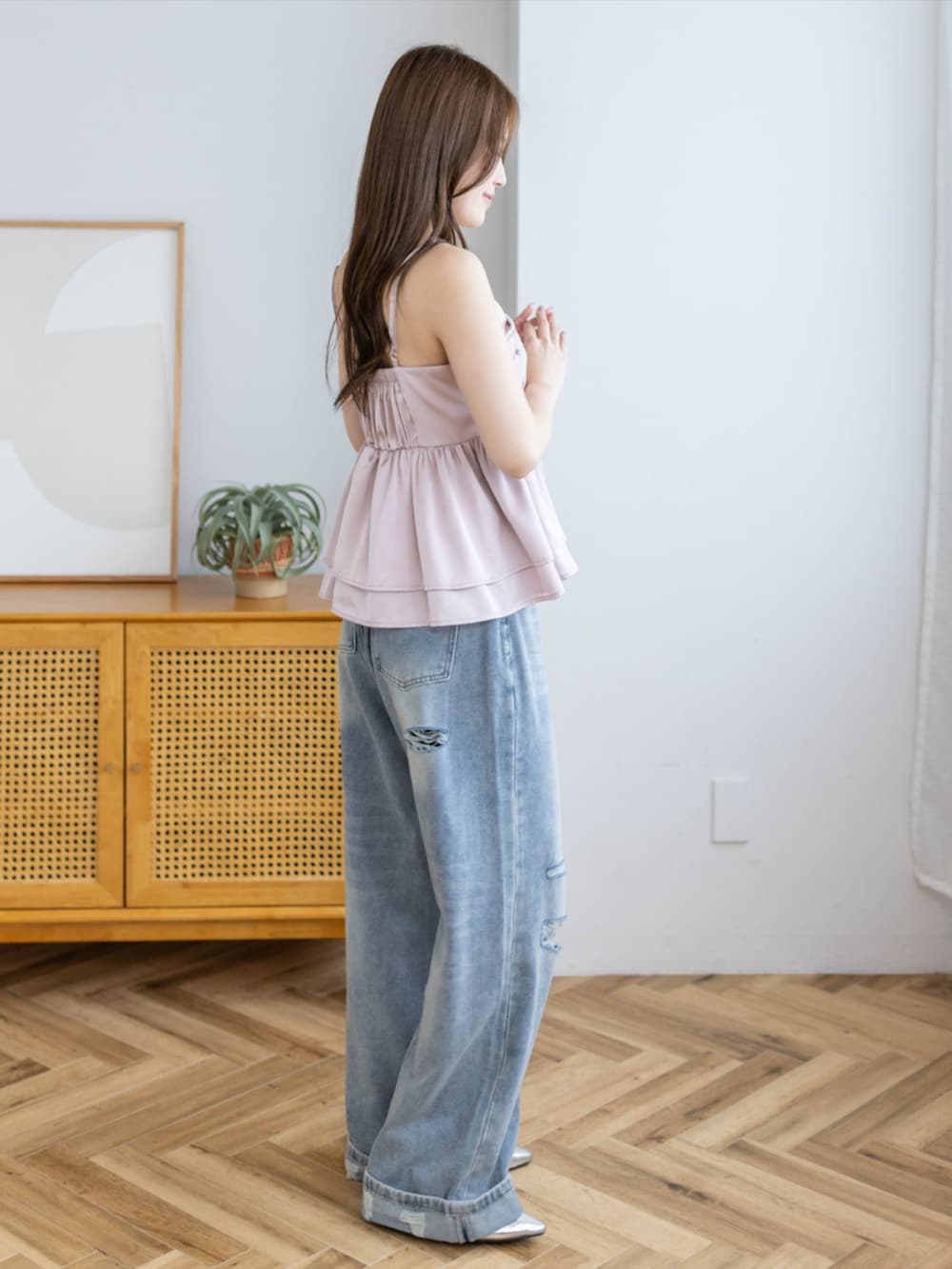 シルバー系のパンプス、ブルー系のデニムパンツ、ピンク系のキャミソールを着用したレディースの夏コーディネートの3枚目の写真