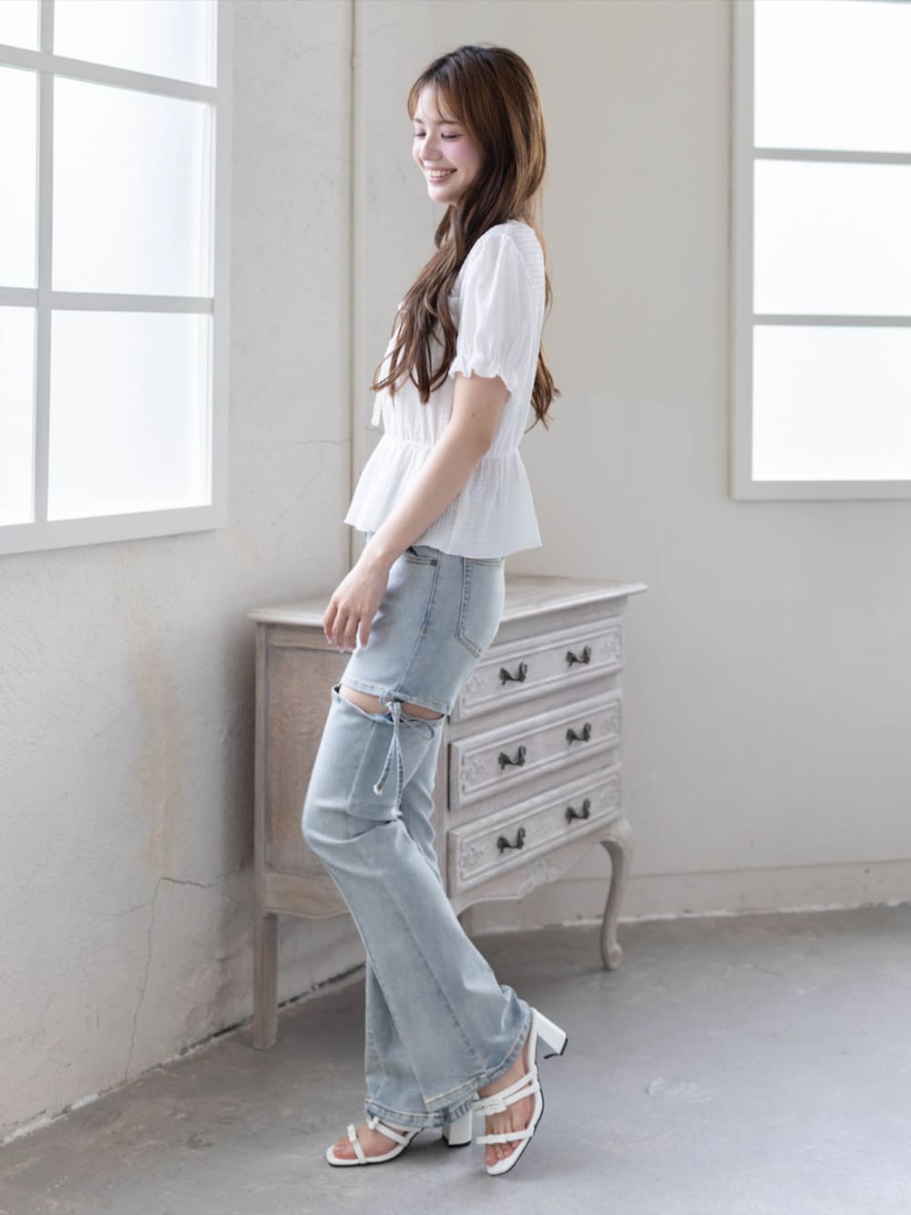 ブルー系のデニムパンツ、ホワイト系のサンダル、ホワイト系のシャツ/ブラウスを着用したレディースの夏コーディネートの3枚目の写真