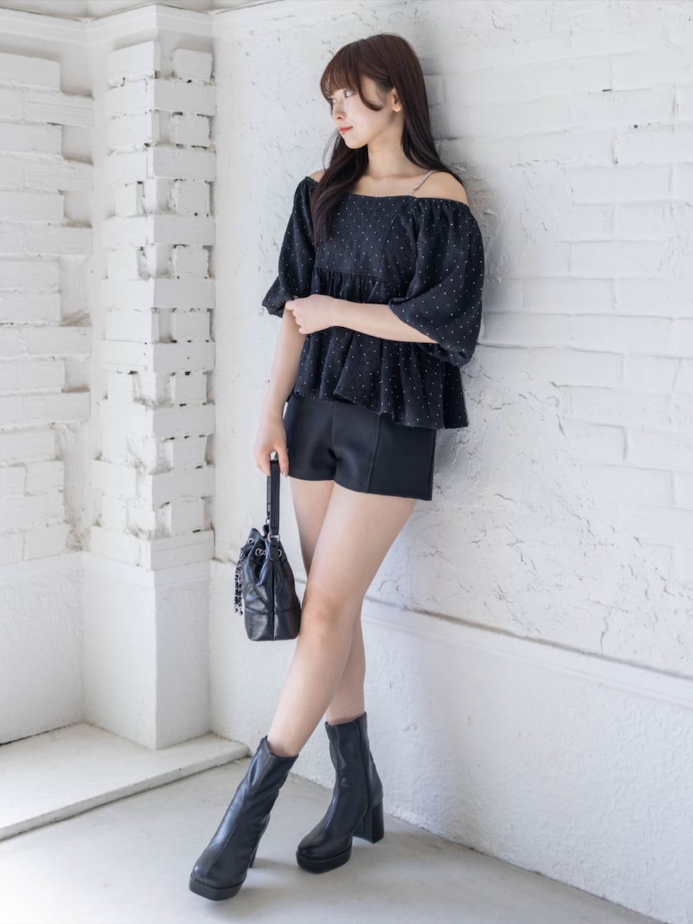 ブラック系のブーツ、ブラック系のその他パンツ、ブラック系のハンドバッグを着用したレディースの春コーディネートの2枚目の写真