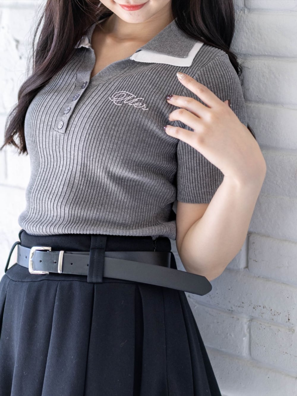 ブラック系のブーツ、ブラック系のスカート、ブラック系のハンドバッグを着用したレディースの春コーディネートの5枚目の写真