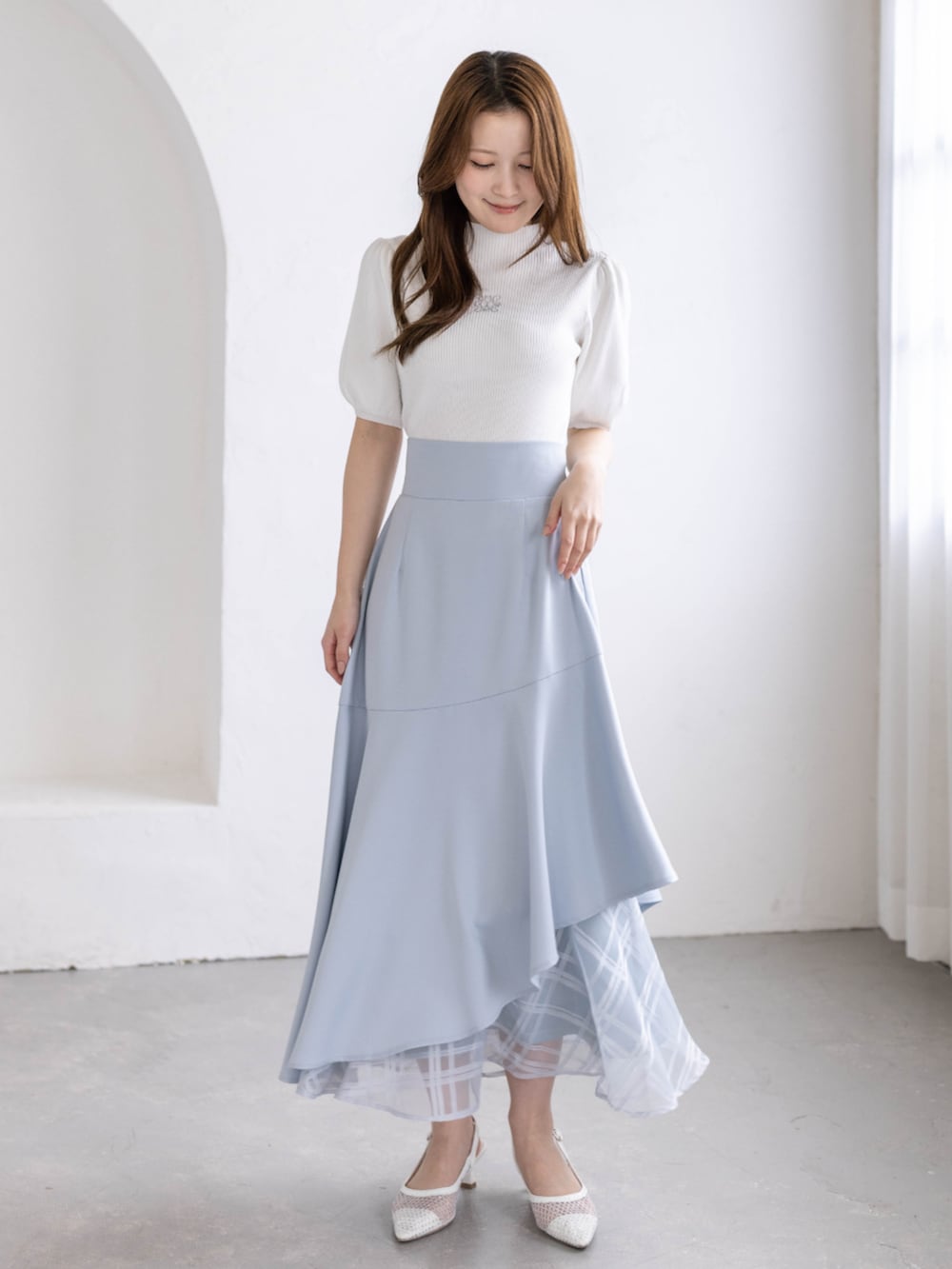 ホワイト系のパンプス、ブルー系のスカート、ホワイト系のニット/セーターを着用したレディースの春コーディネートの2枚目の写真