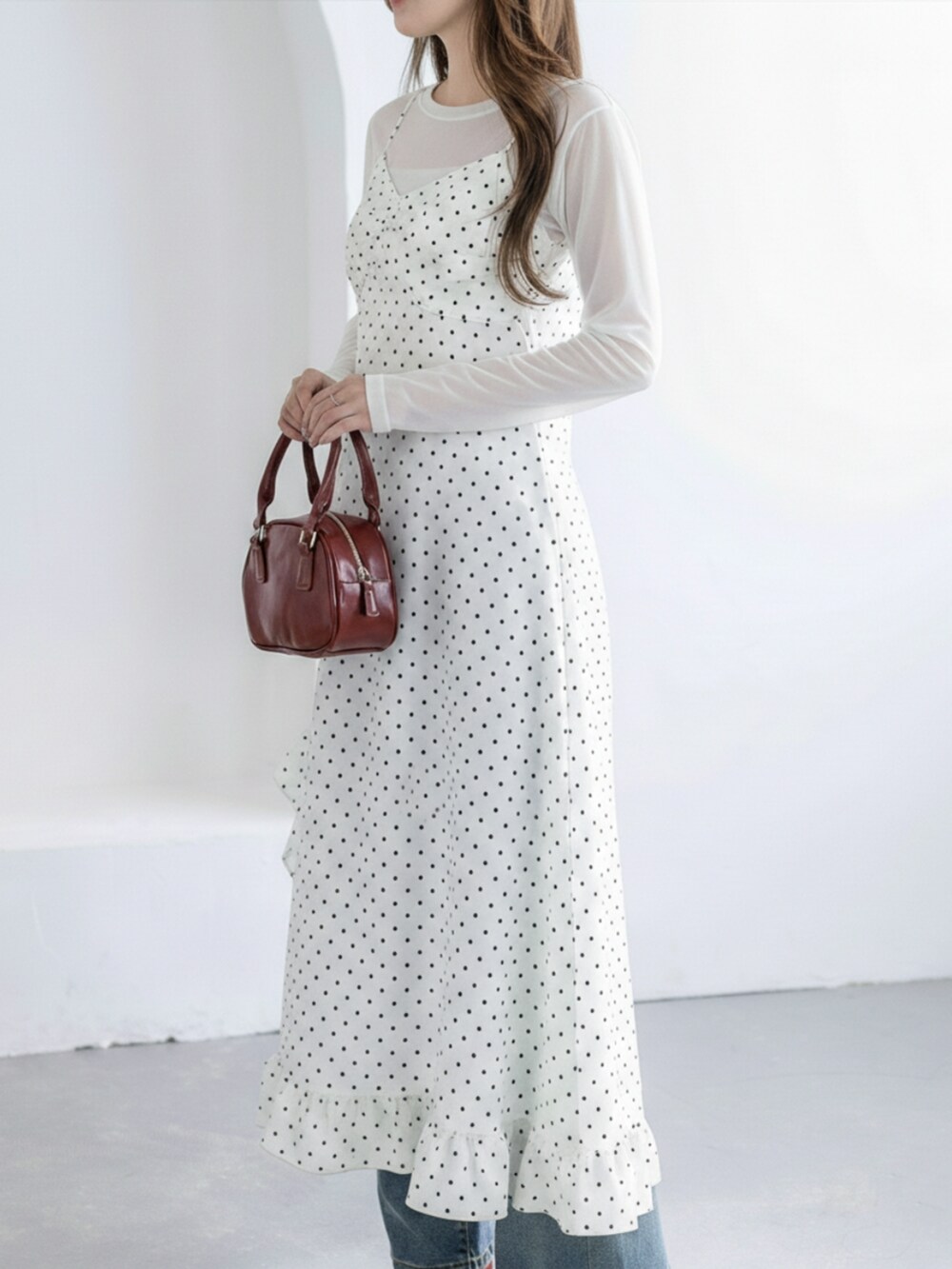 ブルー系のデニムパンツ、レッド系のパンプス、ホワイト系のワンピースを着用したレディースの冬コーディネートの2枚目の写真