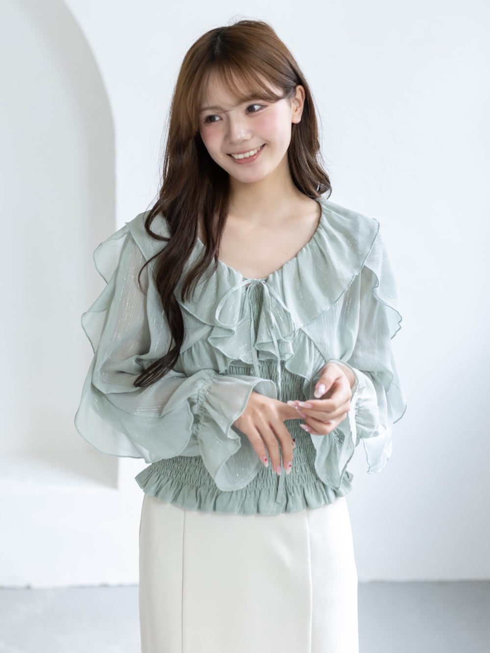 ホワイト系のスカート、ホワイト系のパンプス、グリーン系のシャツ/ブラウスを着用したレディースの春コーディネートの3枚目の写真