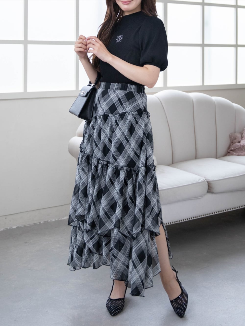 ブラック系のハンドバッグ、ブラック系のパンプス、ブラック系のニット/セーターを着用したレディースの夏コーディネートの3枚目の写真