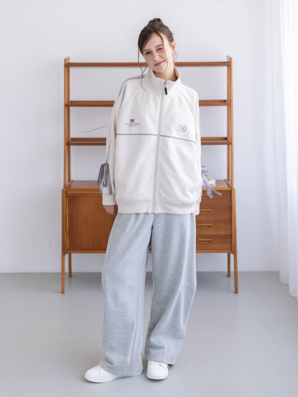 ゴールド系のスニーカー、グレー系のスウェットパンツ、ホワイト系のTシャツ/カットソーを着用したレディースの秋コーディネートの4枚目の写真