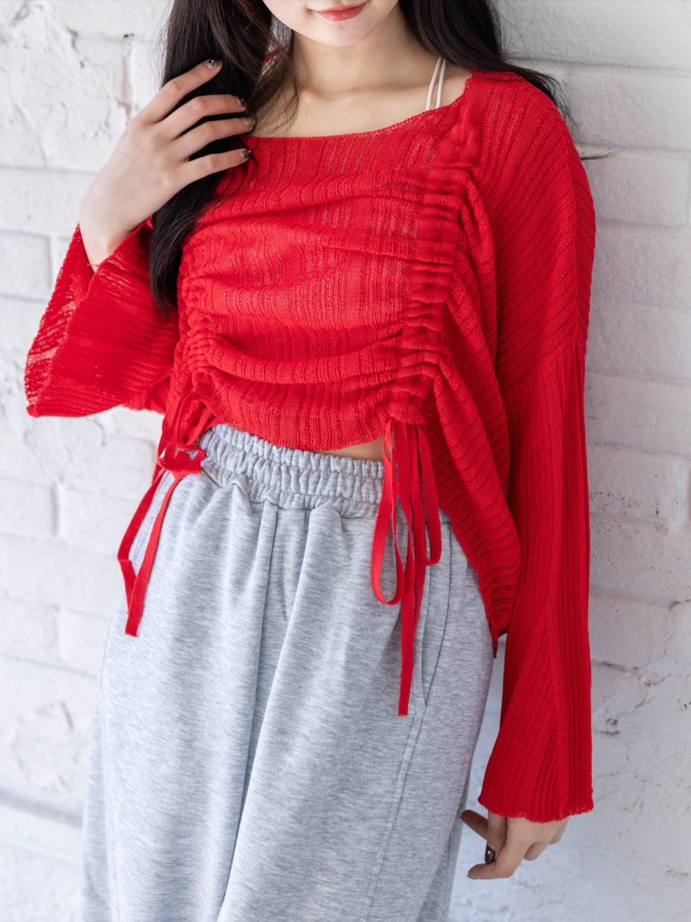 ホワイト系のスニーカー、グレー系のスウェットパンツ、レッド系のニット/セーターを着用したレディースの春コーディネートの5枚目の写真