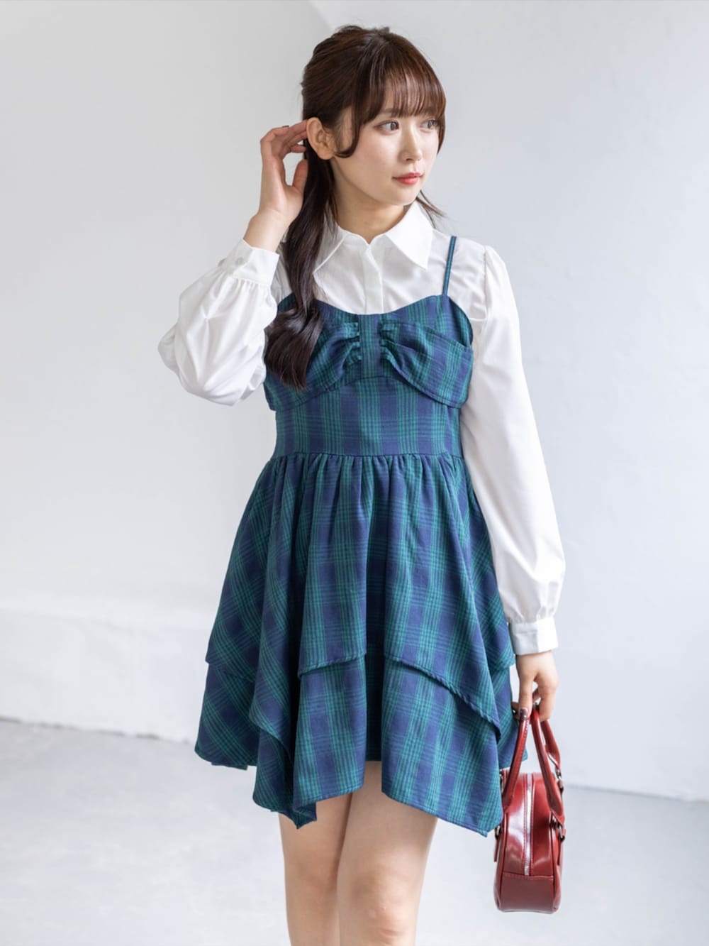 グリーン系のワンピース、ブラック系のブーツ、ホワイト系のシャツ/ブラウスを着用したレディースの春コーディネートの4枚目の写真