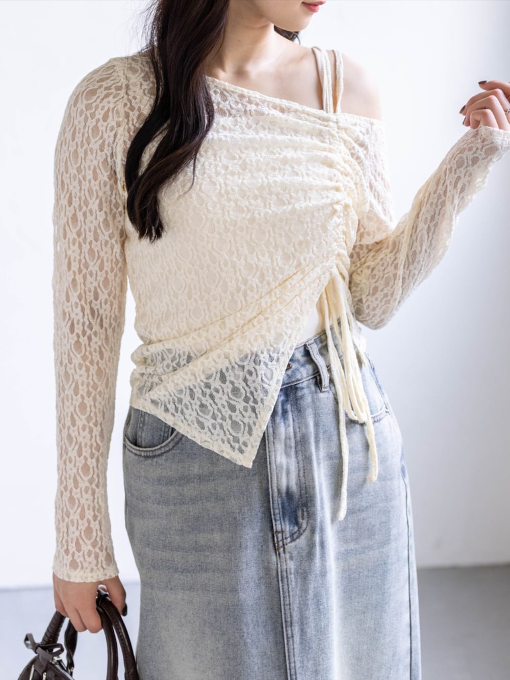 ブラウン系のボストンバッグ、ホワイト系のスニーカー、ブルー系のスカートを着用したレディースの春コーディネートの5枚目の写真