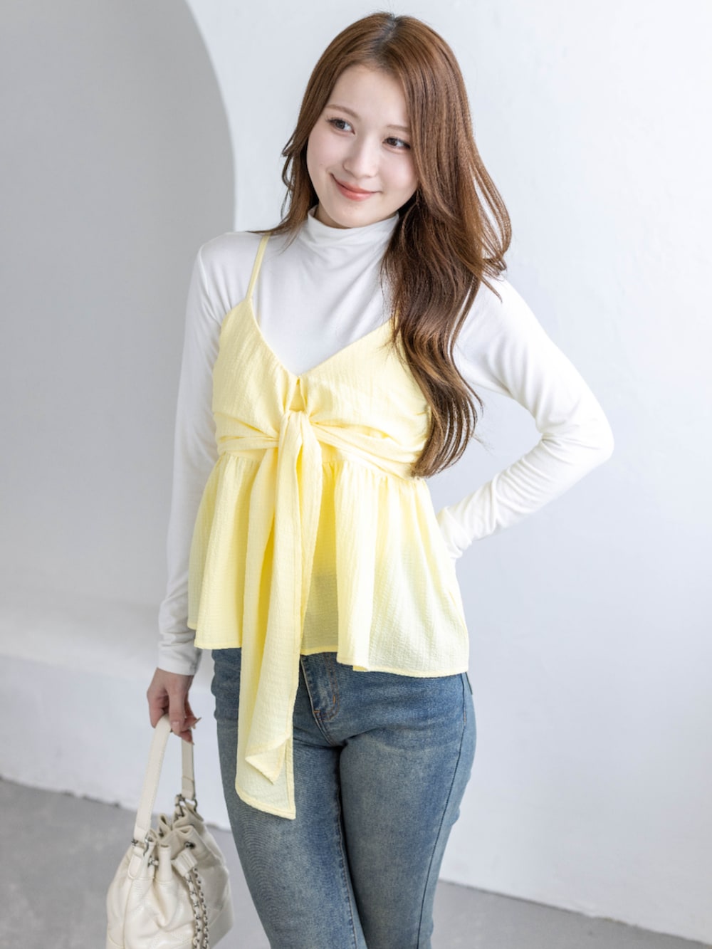 ブルー系のデニムパンツ、ホワイト系のTシャツ/カットソー、ホワイト系のハンドバッグを着用したレディースの春コーディネートの4枚目の写真