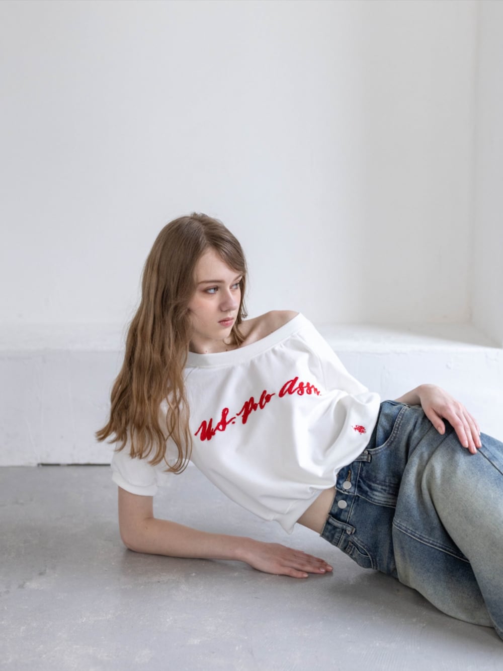 ブラック系のブーツ、ホワイト系のTシャツ/カットソー、ブルー系のデニムスカートを着用したレディースの夏コーディネートの5枚目の写真