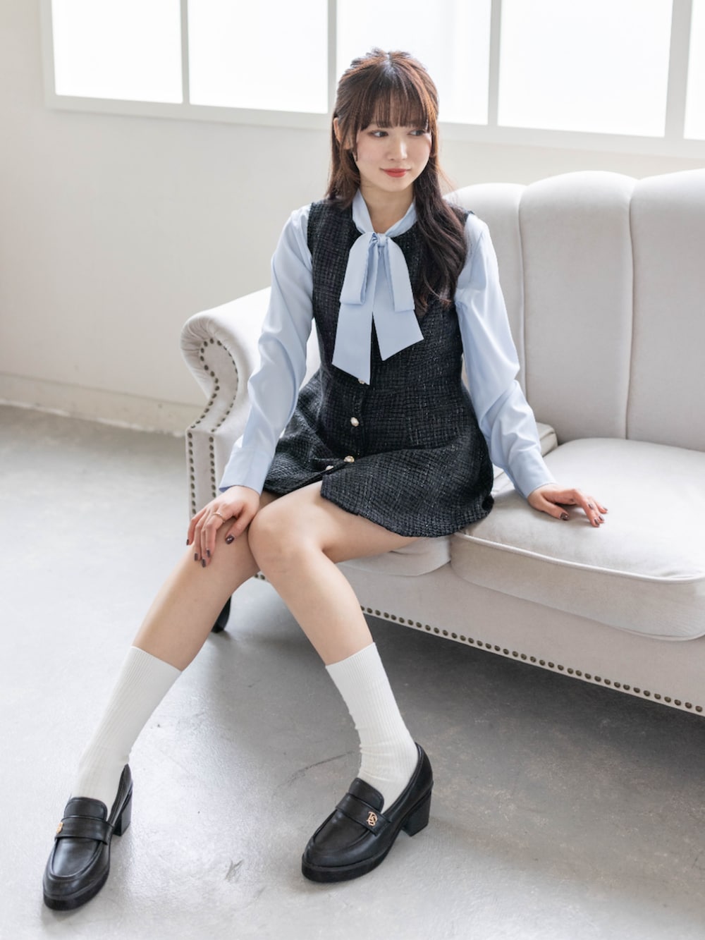 ブラック系のローファー、ブラック系のチュニック、ブルー系のシャツ/ブラウスを着用したレディースの春コーディネートの3枚目の写真