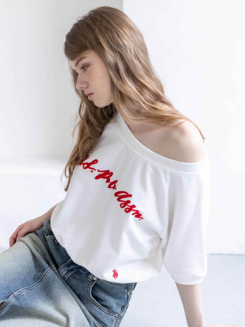 ブラック系のブーツ、ホワイト系のTシャツ/カットソー、ブルー系のデニムスカートを着用したレディースの夏コーディネートの4枚目の写真