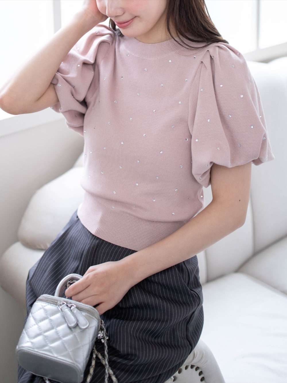 シルバー系のパンプス、グレー系のスラックス、ピンク系のニット/セーターを着用したレディースの夏コーディネートの5枚目の写真