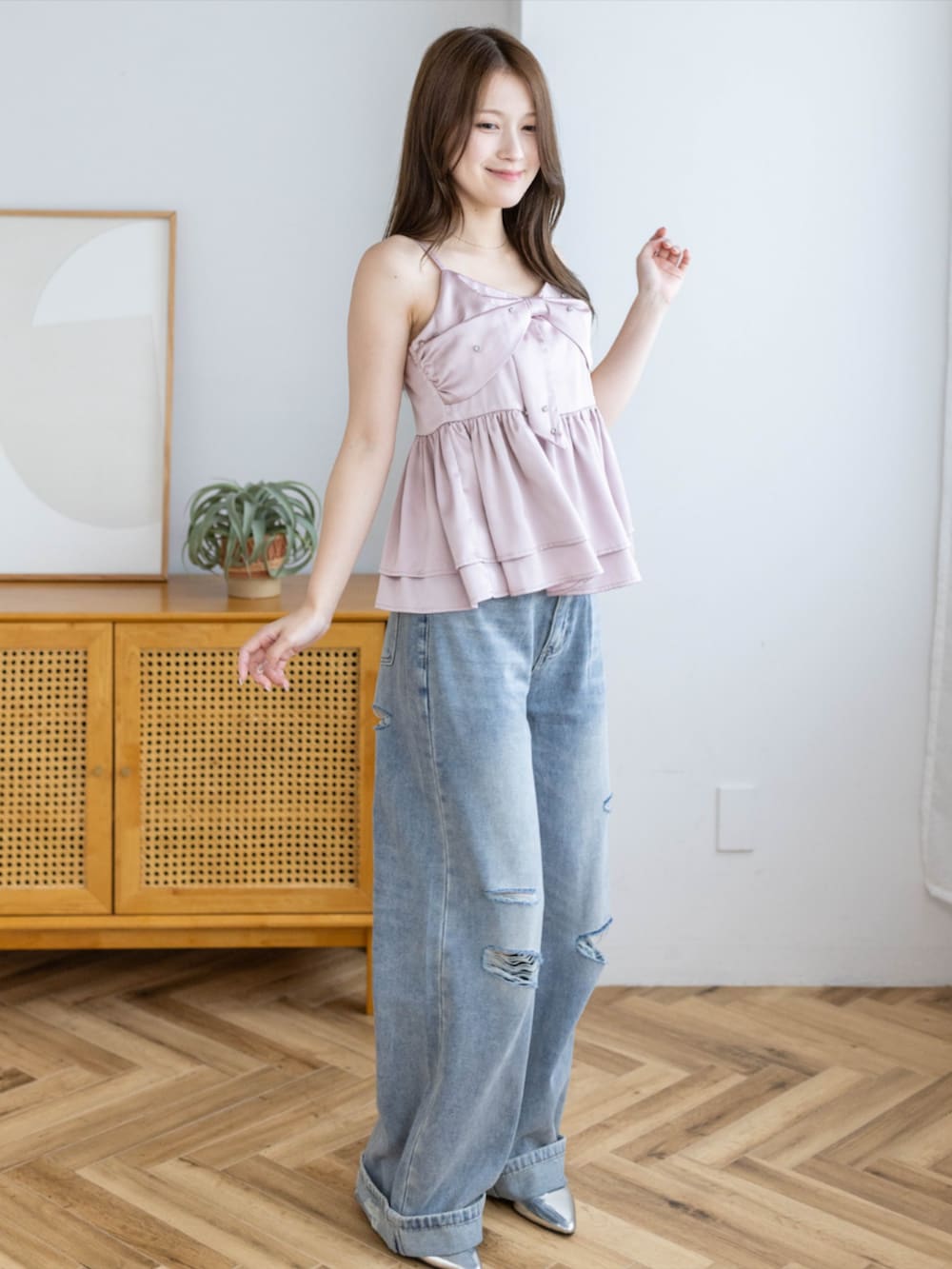 シルバー系のパンプス、ブルー系のデニムパンツ、ピンク系のキャミソールを着用したレディースの夏コーディネートの4枚目の写真