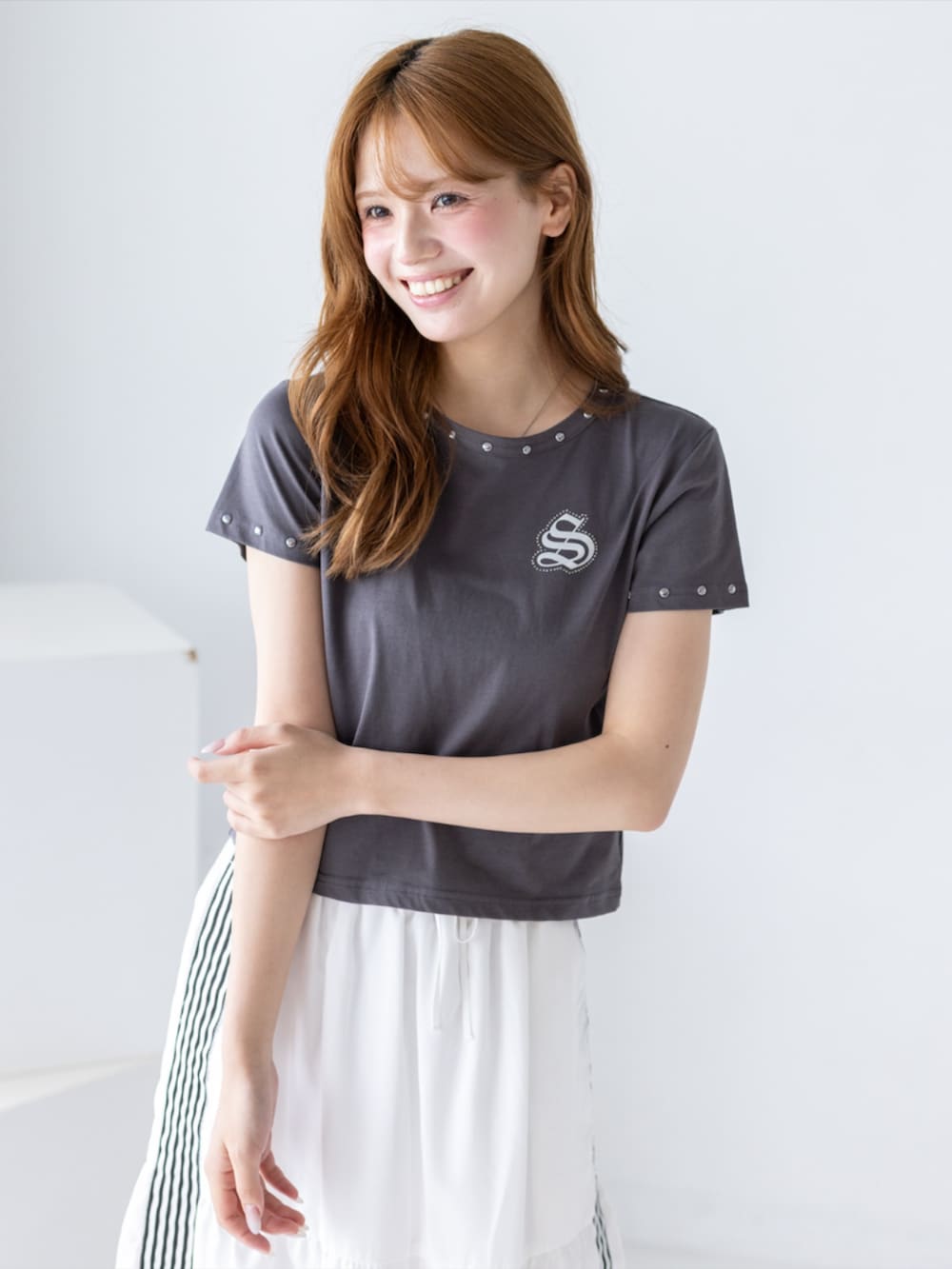 ブラック系のブーツ、ホワイト系のスカート、グレー系のTシャツ/カットソーを着用したレディースの夏コーディネートの5枚目の写真