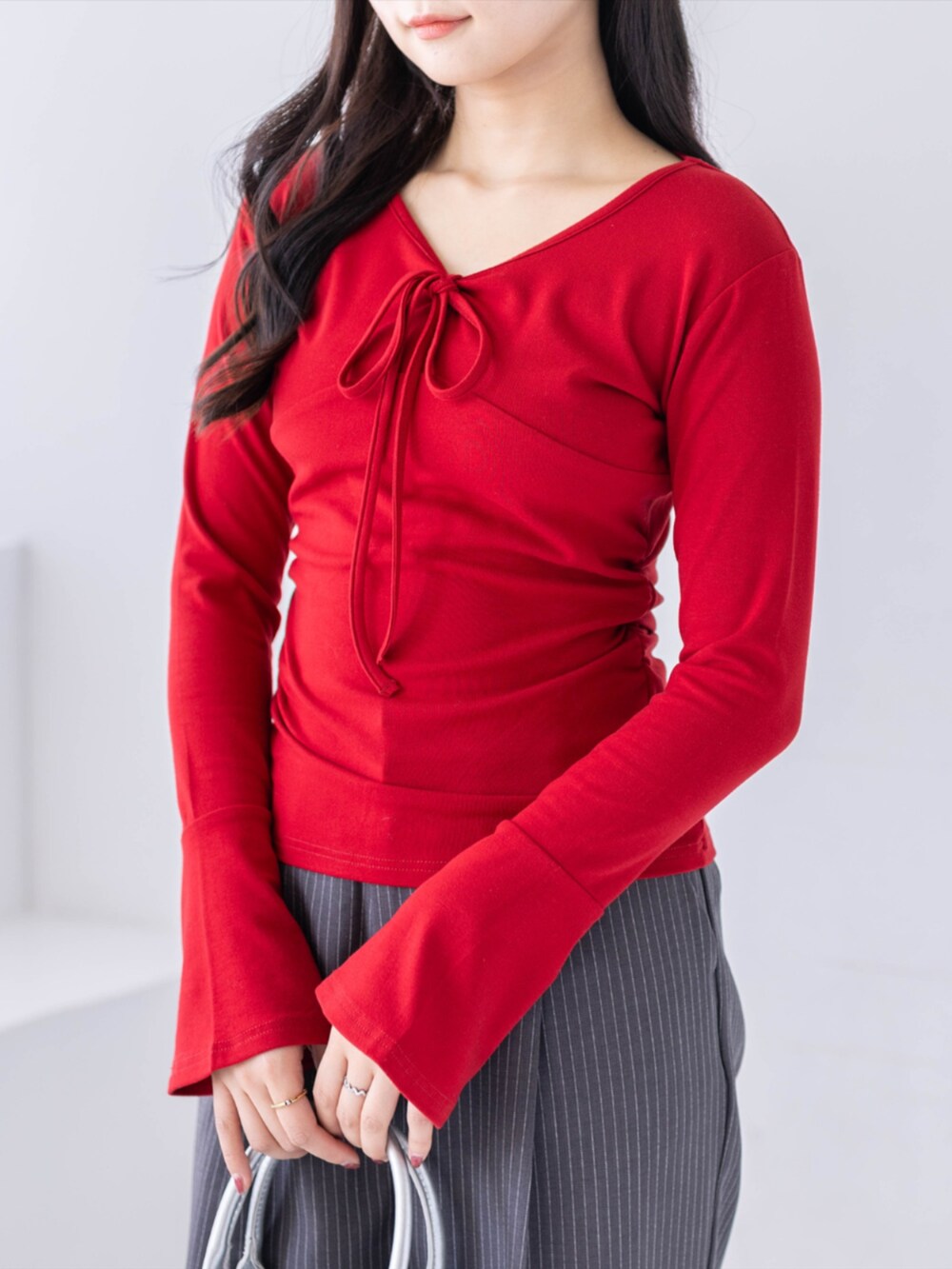 シルバー系のパンプス、グレー系のスラックス、レッド系のTシャツ/カットソーを着用したレディースの春コーディネートの3枚目の写真