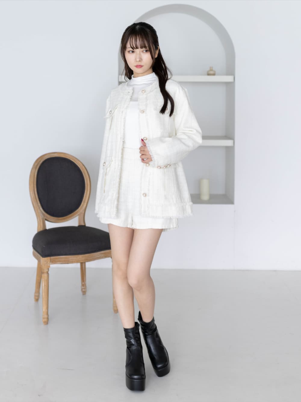 ホワイト系のTシャツ/カットソー、ブラック系のブーツ、ホワイト系のノーカラージャケットを着用したレディースの秋コーディネートの2枚目の写真