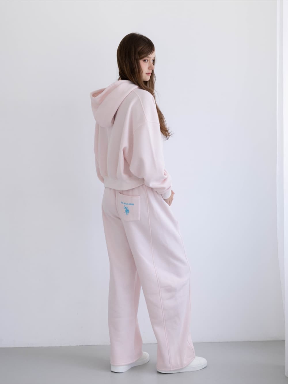 ピンク系のスニーカー、ピンク系のスウェットパンツ、ピンク系のパーカーを着用したレディースの秋コーディネートの2枚目の写真