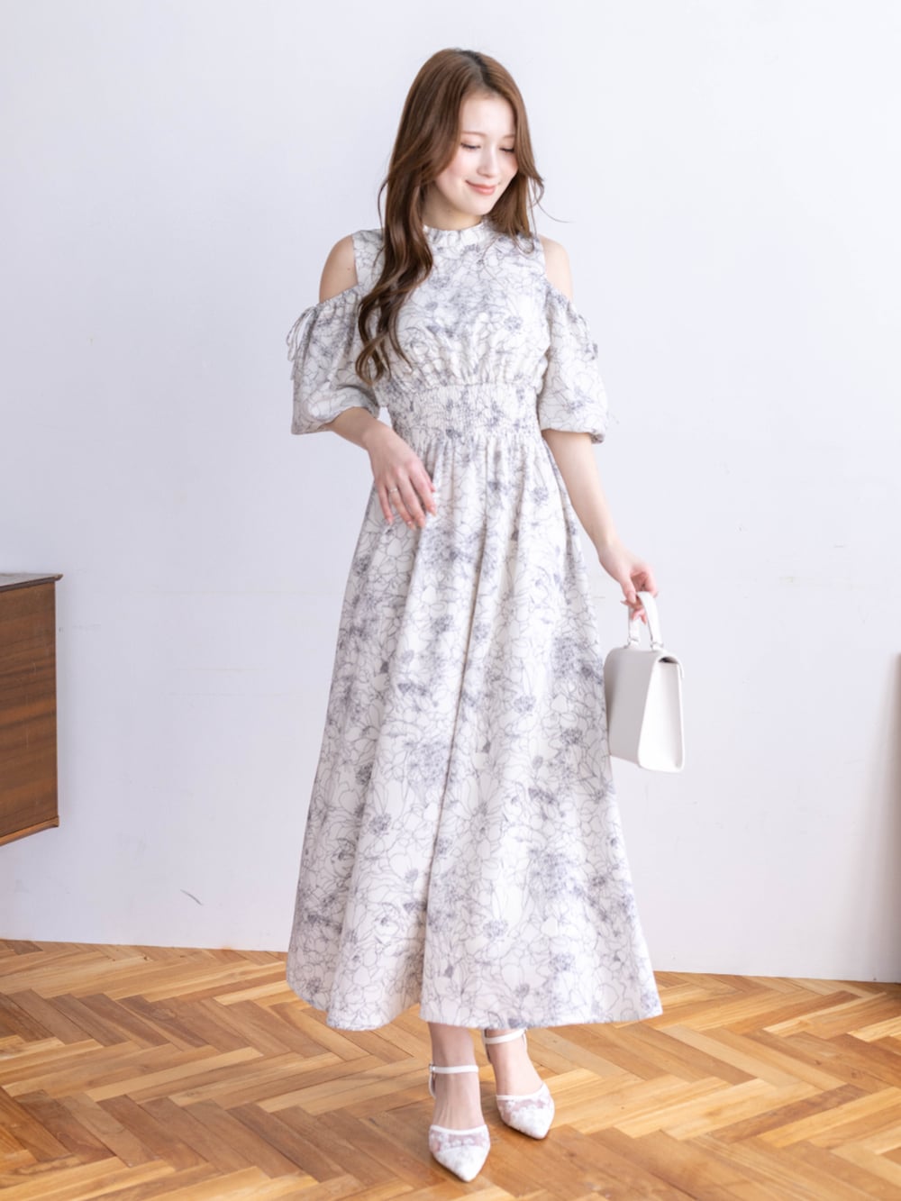 ホワイト系のワンピース、ホワイト系のハンドバッグを着用したレディースの冬コーディネートの3枚目の写真