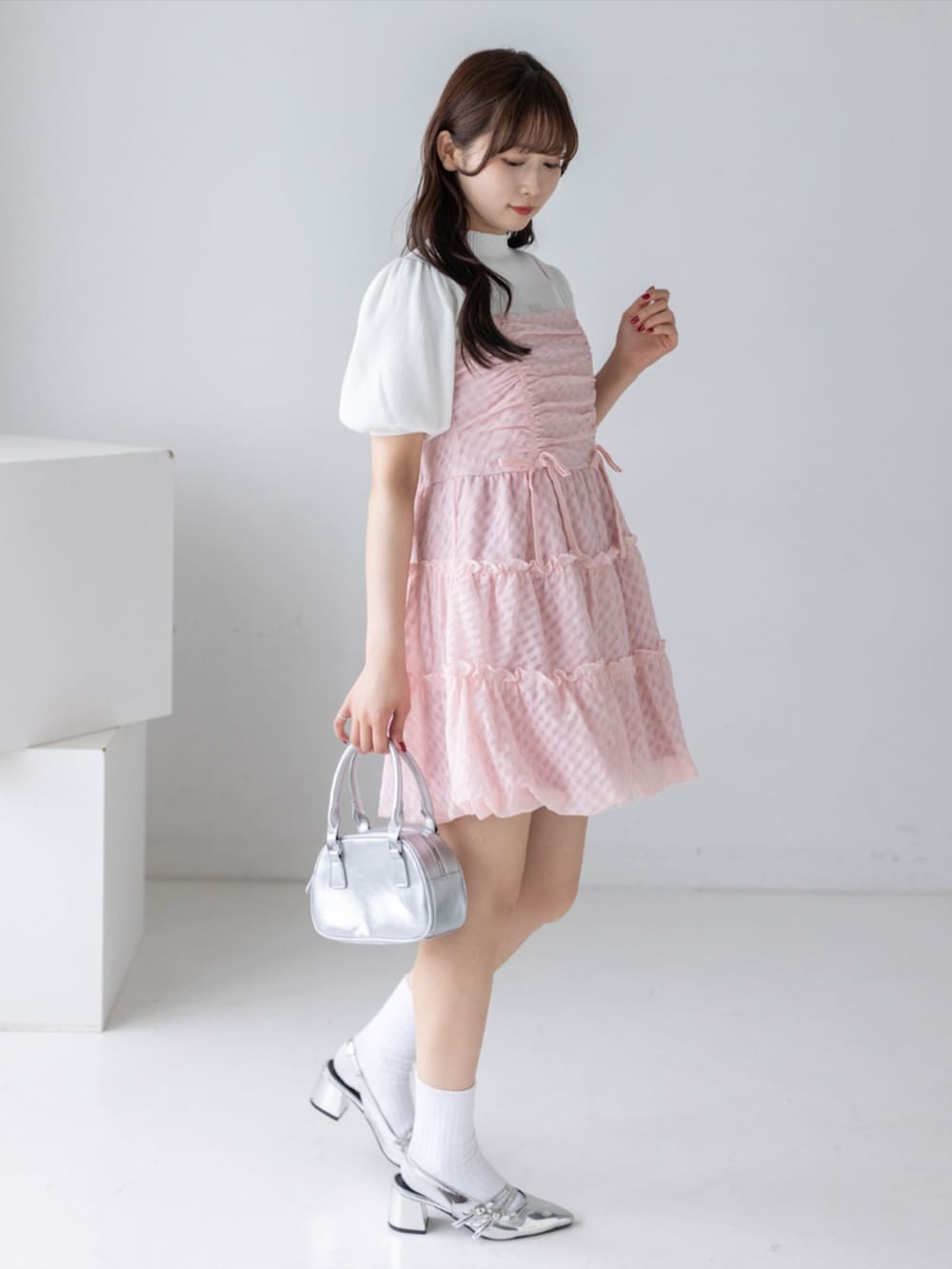シルバー系のパンプス、ホワイト系のニット/セーター、ピンク系のワンピースを着用したレディースの春コーディネートの4枚目の写真