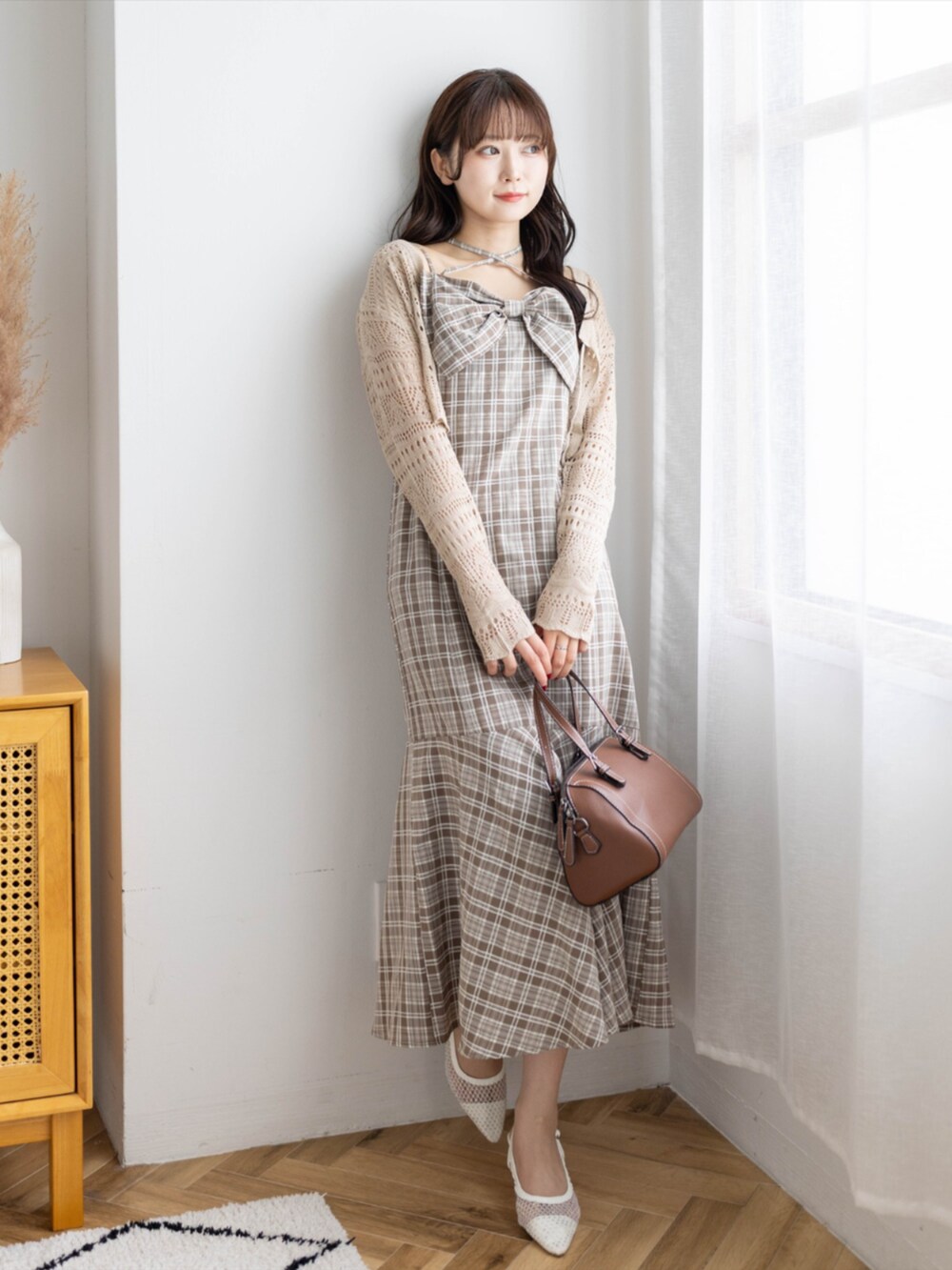ベージュ系のボストンバッグ、ホワイト系のパンプス、ブラウン系のニット/セーターを着用したレディースの春コーディネートの3枚目の写真