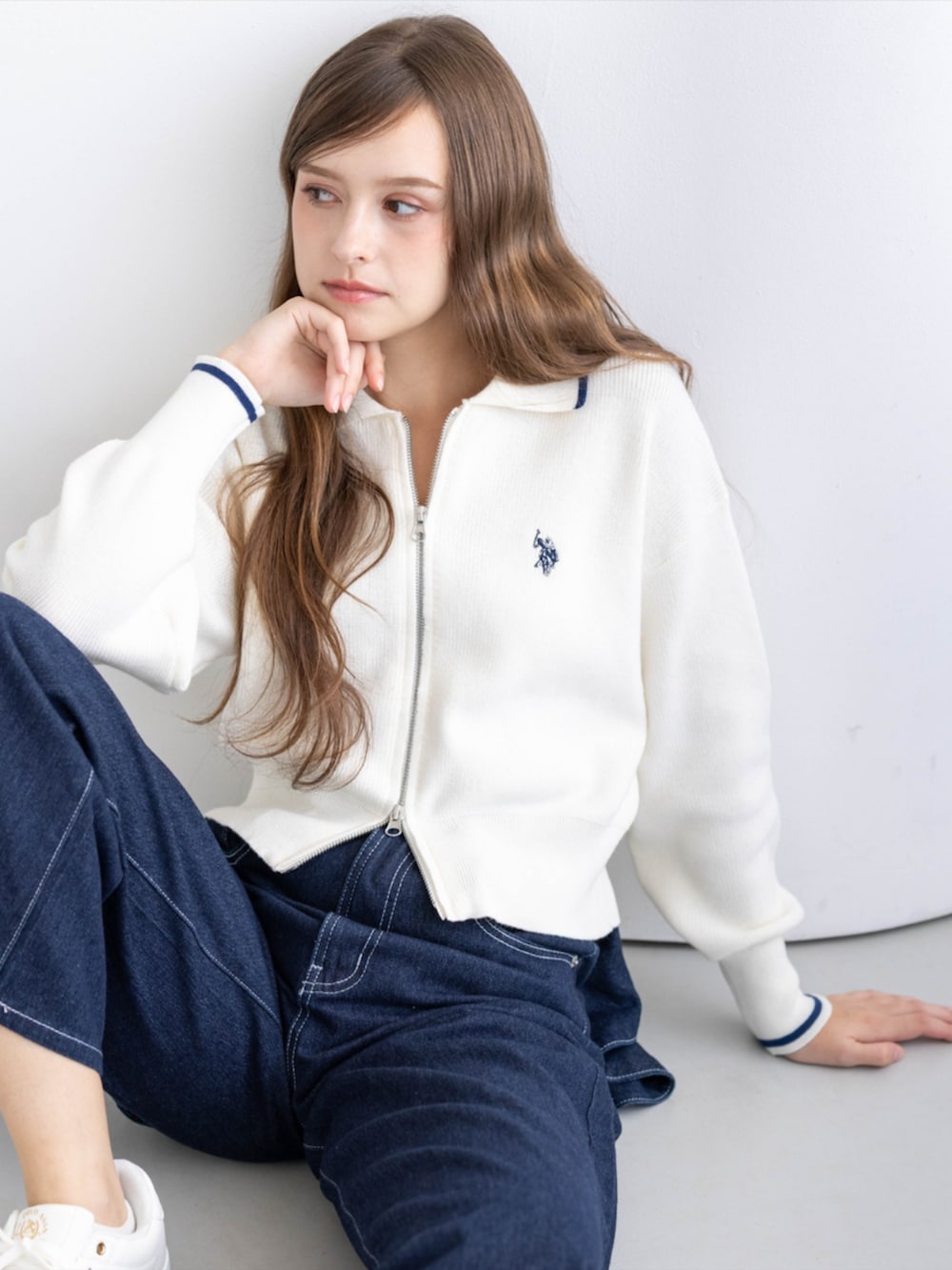 ゴールド系のスニーカー、ブルー系のデニムパンツ、ホワイト系のTシャツ/カットソーを着用したレディースの秋コーディネートの7枚目の写真