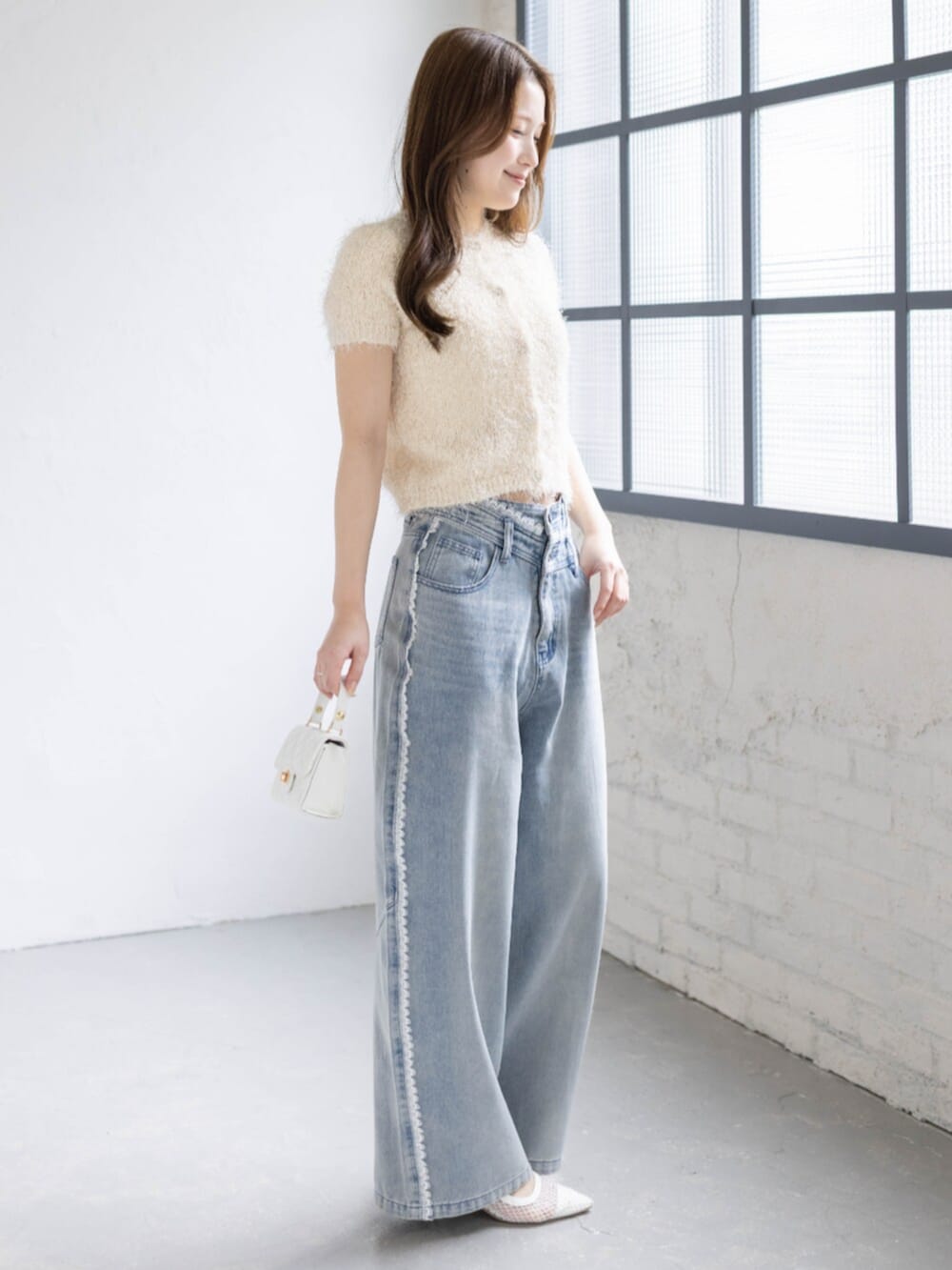 ホワイト系のパンプス、ホワイト系のカーディガン/ボレロ、ブルー系のデニムパンツを着用したレディースの春コーディネートの2枚目の写真