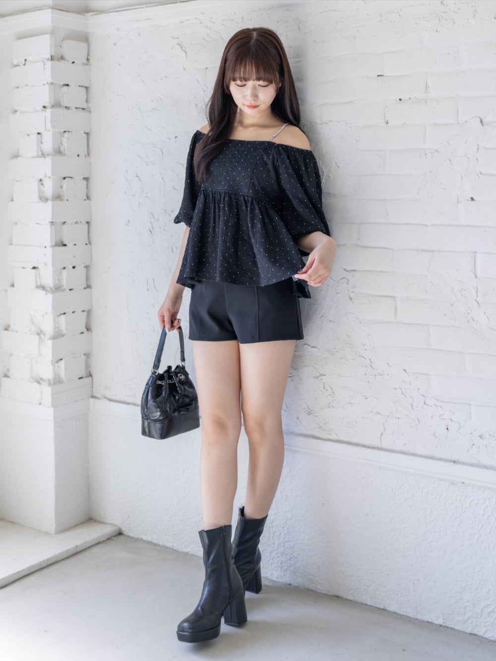 ブラック系のブーツ、ブラック系のその他パンツ、ブラック系のハンドバッグを着用したレディースの春コーディネートの3枚目の写真