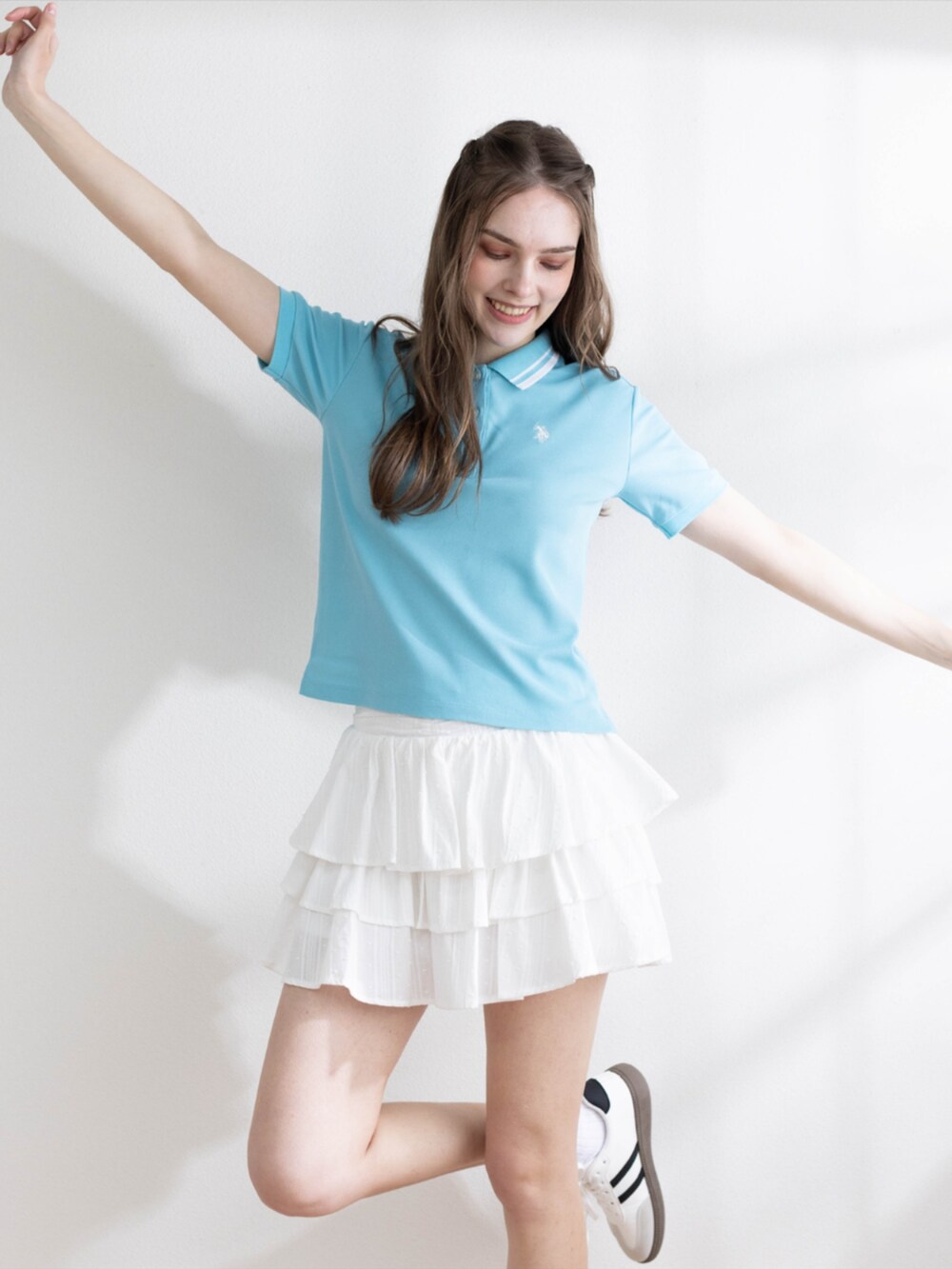 ホワイト系のその他パンツ、ホワイト系のスニーカー、ブルー系のポロシャツを着用したレディースの夏コーディネートの6枚目の写真