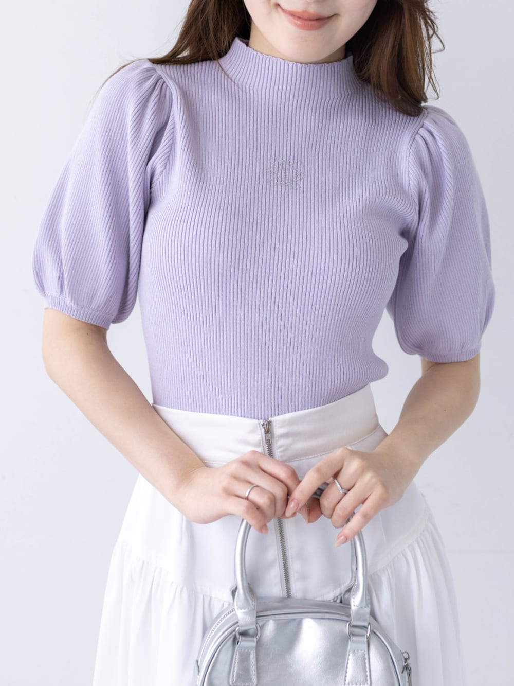 ホワイト系のスカート、ホワイト系のパンプス、パープル系のニット/セーターを着用したレディースの春コーディネートの4枚目の写真