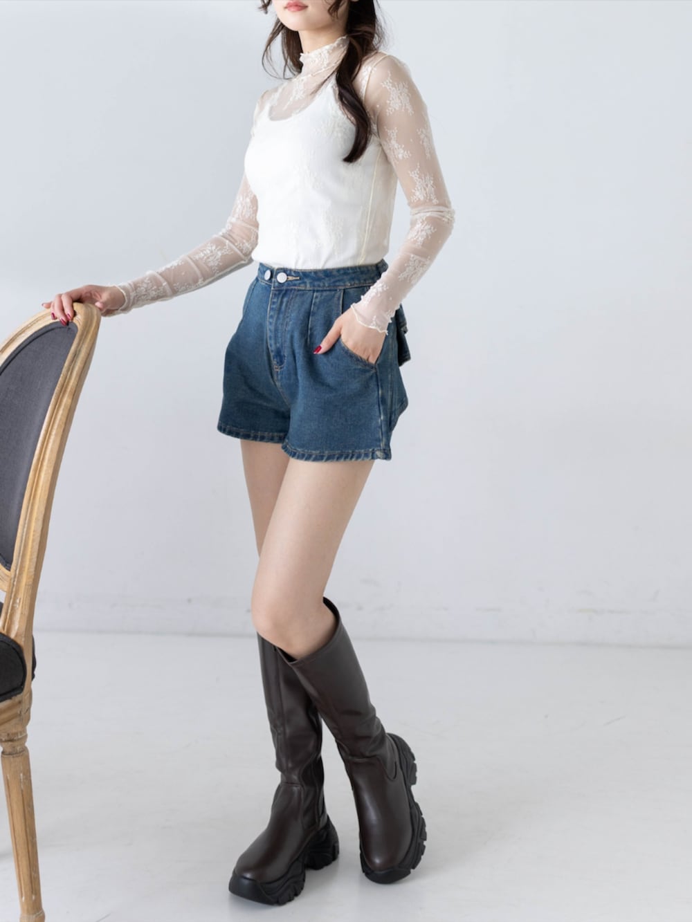 ブルー系のデニムパンツ、ホワイト系のTシャツ/カットソー、ブラウン系のブーツを着用したレディースの秋コーディネートの2枚目の写真