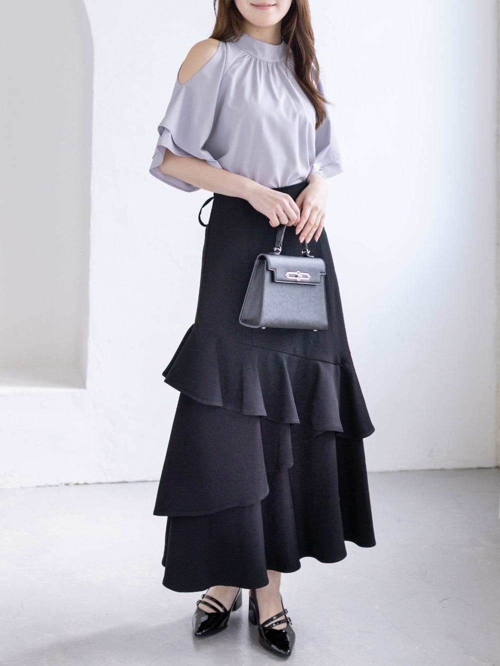 ブラック系のパンプス、グレー系のシャツ/ブラウス、ブラック系のハンドバッグを着用したレディースの春コーディネートの5枚目の写真