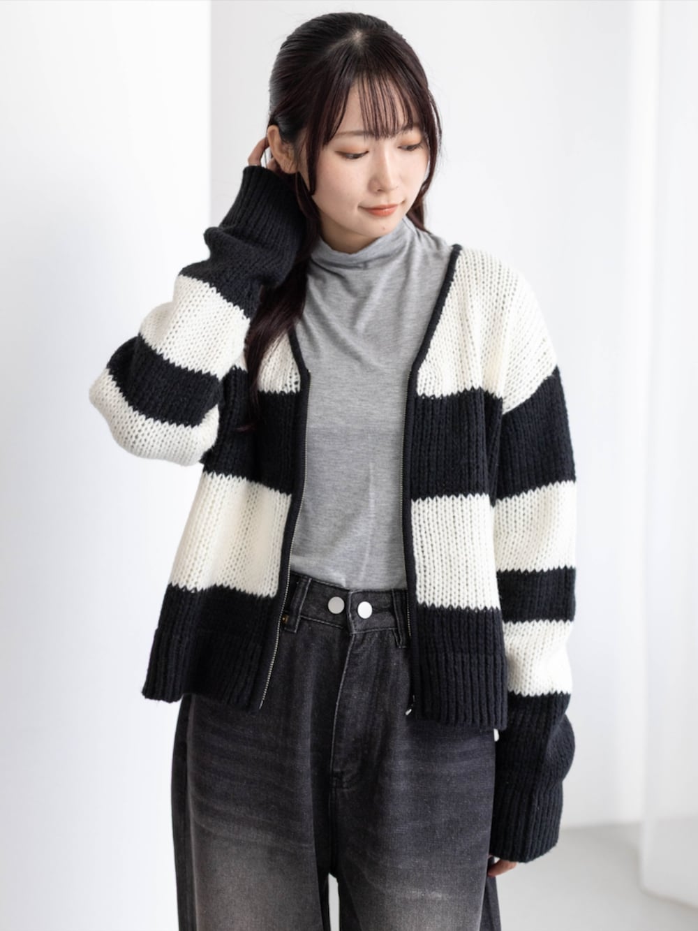グレー系のTシャツ/カットソー、ブラック系のデニムパンツ、ブラック系のブーツを着用したレディースの秋コーディネートの6枚目の写真