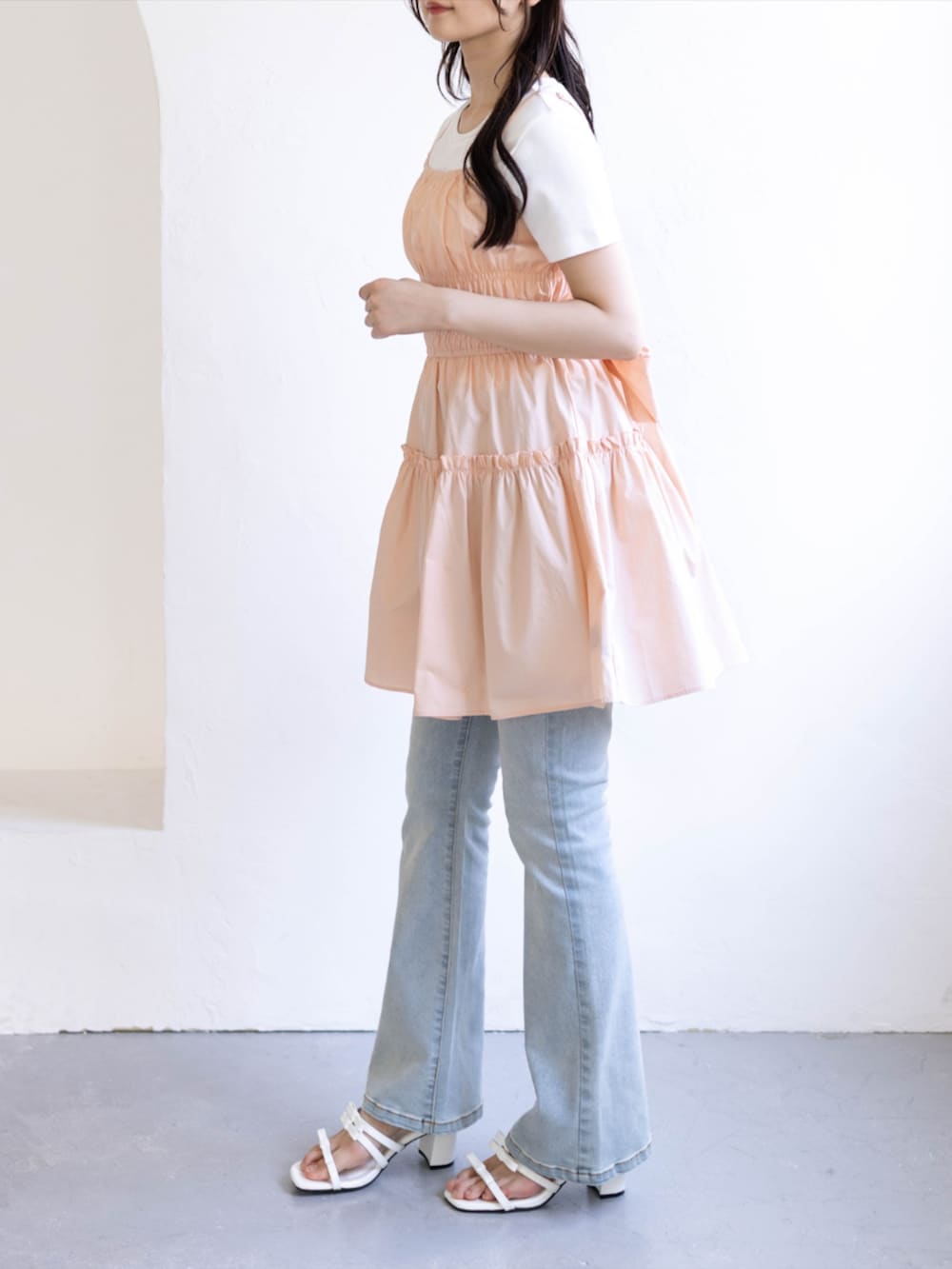 ブルー系のデニムパンツ、ホワイト系のサンダル、ピンク系のワンピースを着用したレディースの夏コーディネートの4枚目の写真