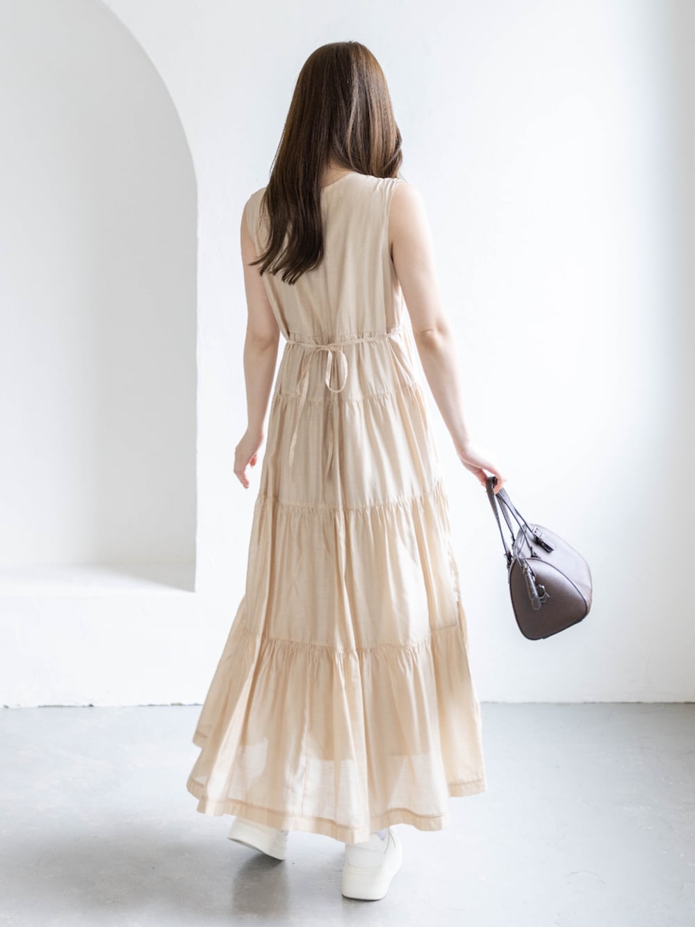 ベージュ系のワンピースを着用したレディースの春コーディネートの4枚目の写真